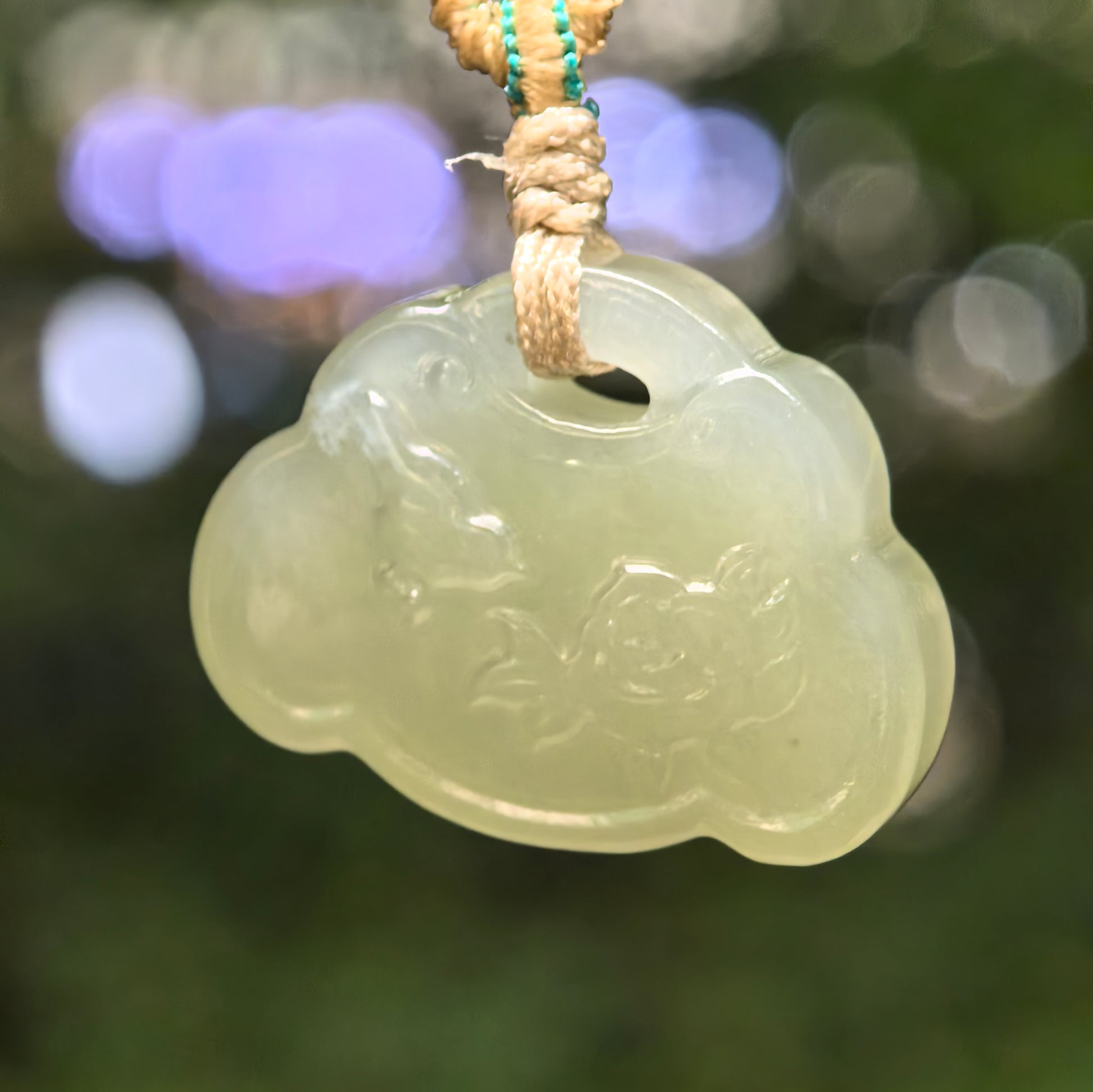 Natural light green Hetian jade lotus fish pendant hanging with woven cord.