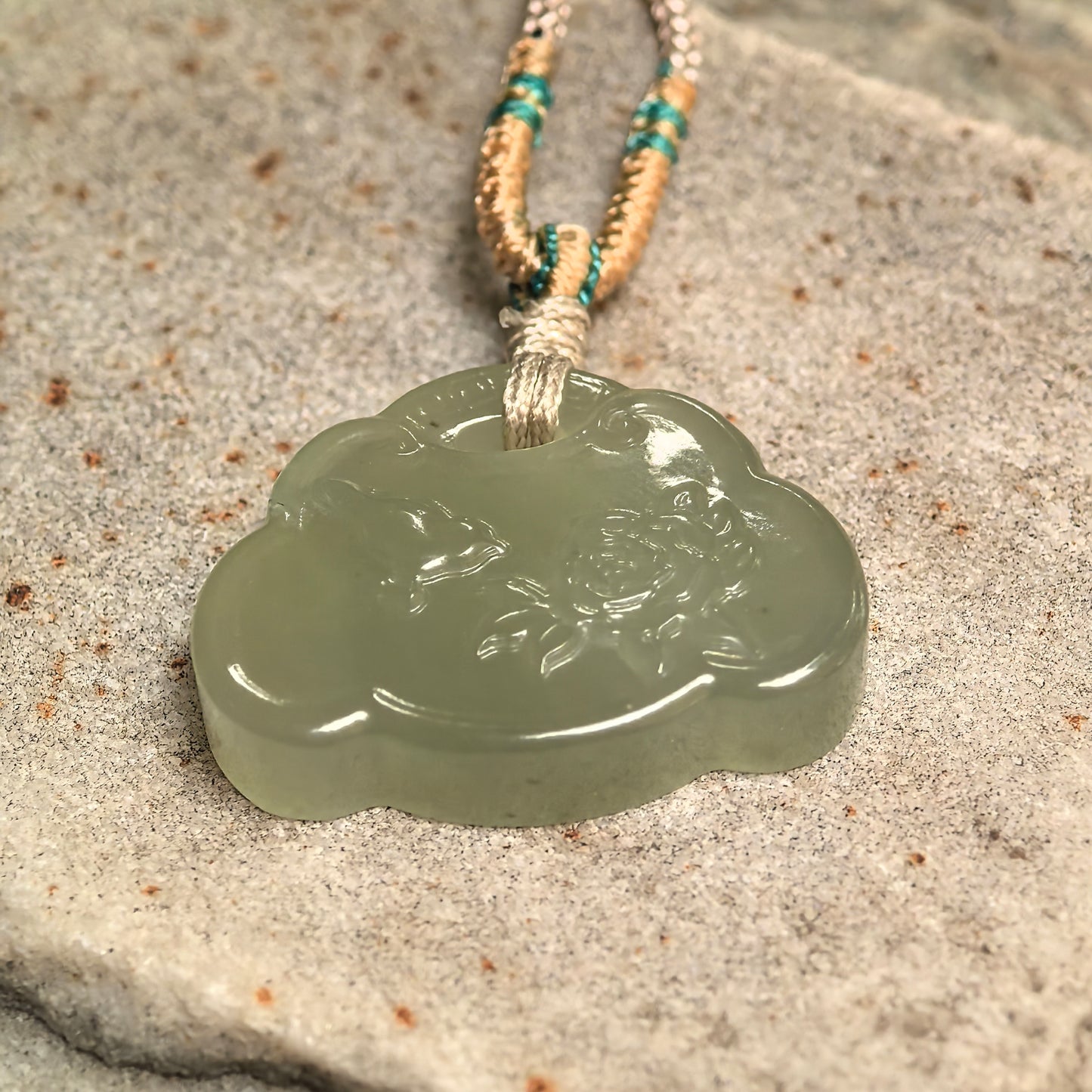 Side view of light green Hetian jade carved pendant showing compact thickness.
