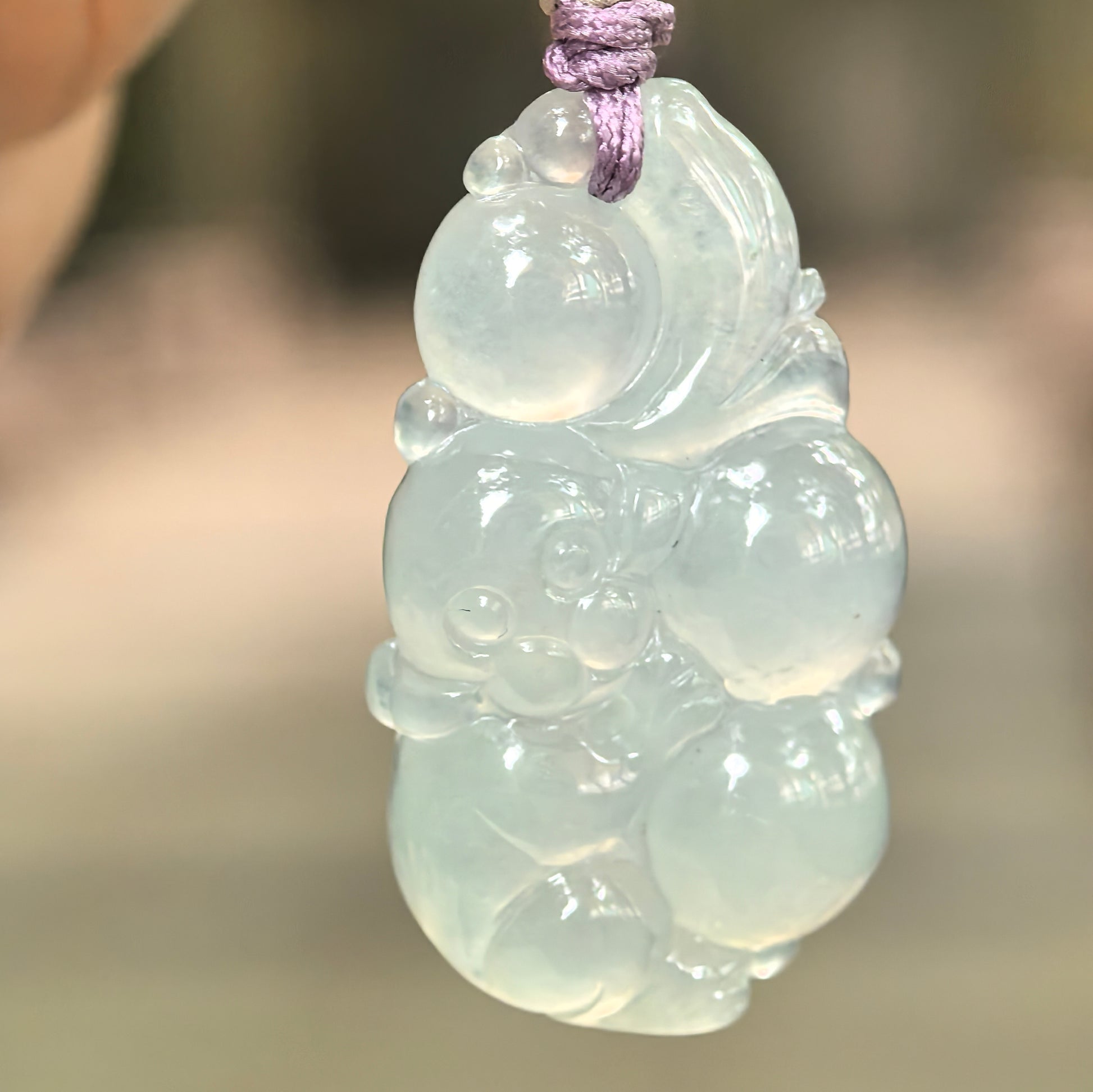 Natural Grade-A glutinous icy pale green monkey jadeite pendant hanging on cord.