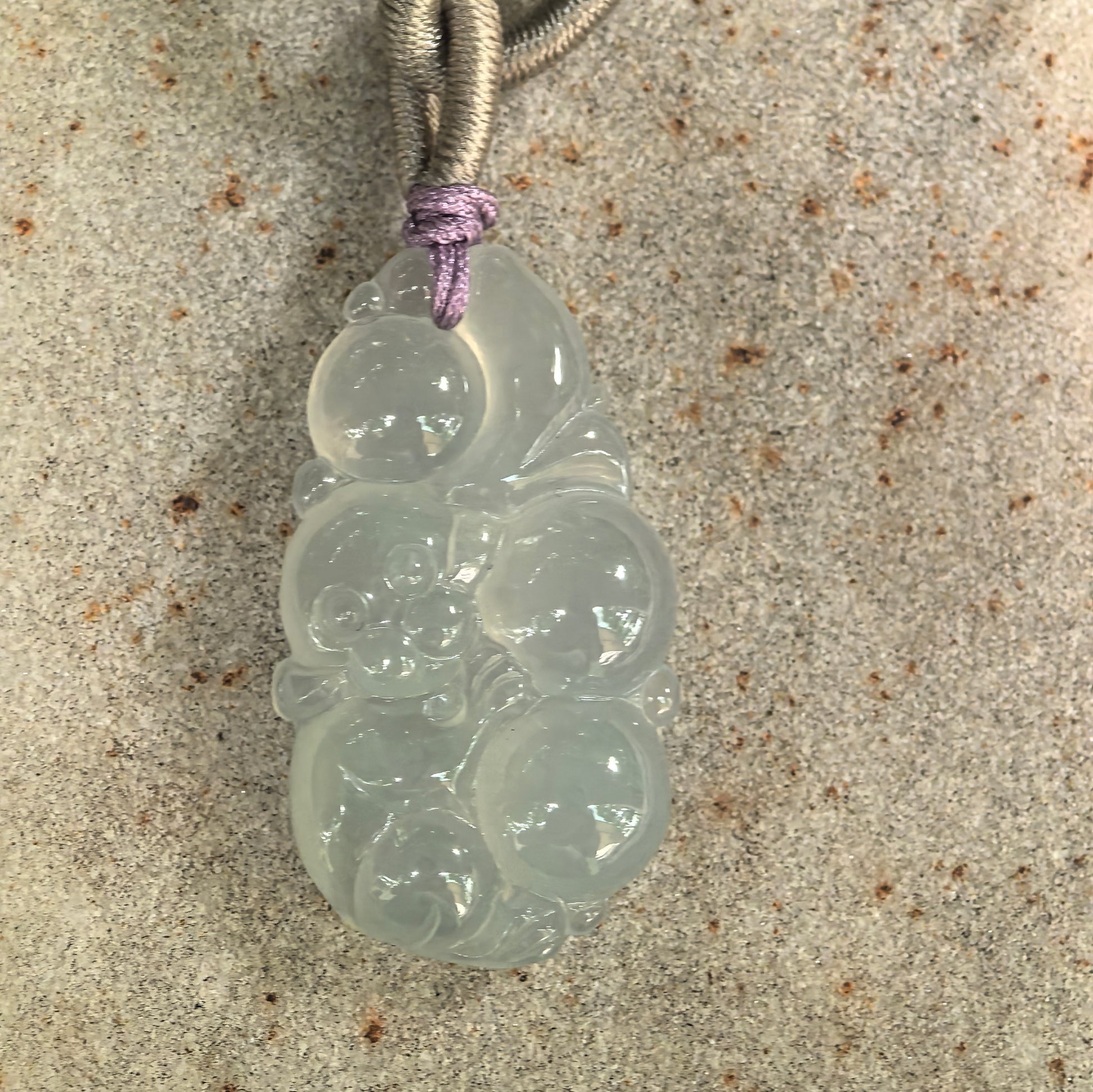 Close-up of carved jadeite monkey holding longevity peaches with smooth gelatinous luster.
