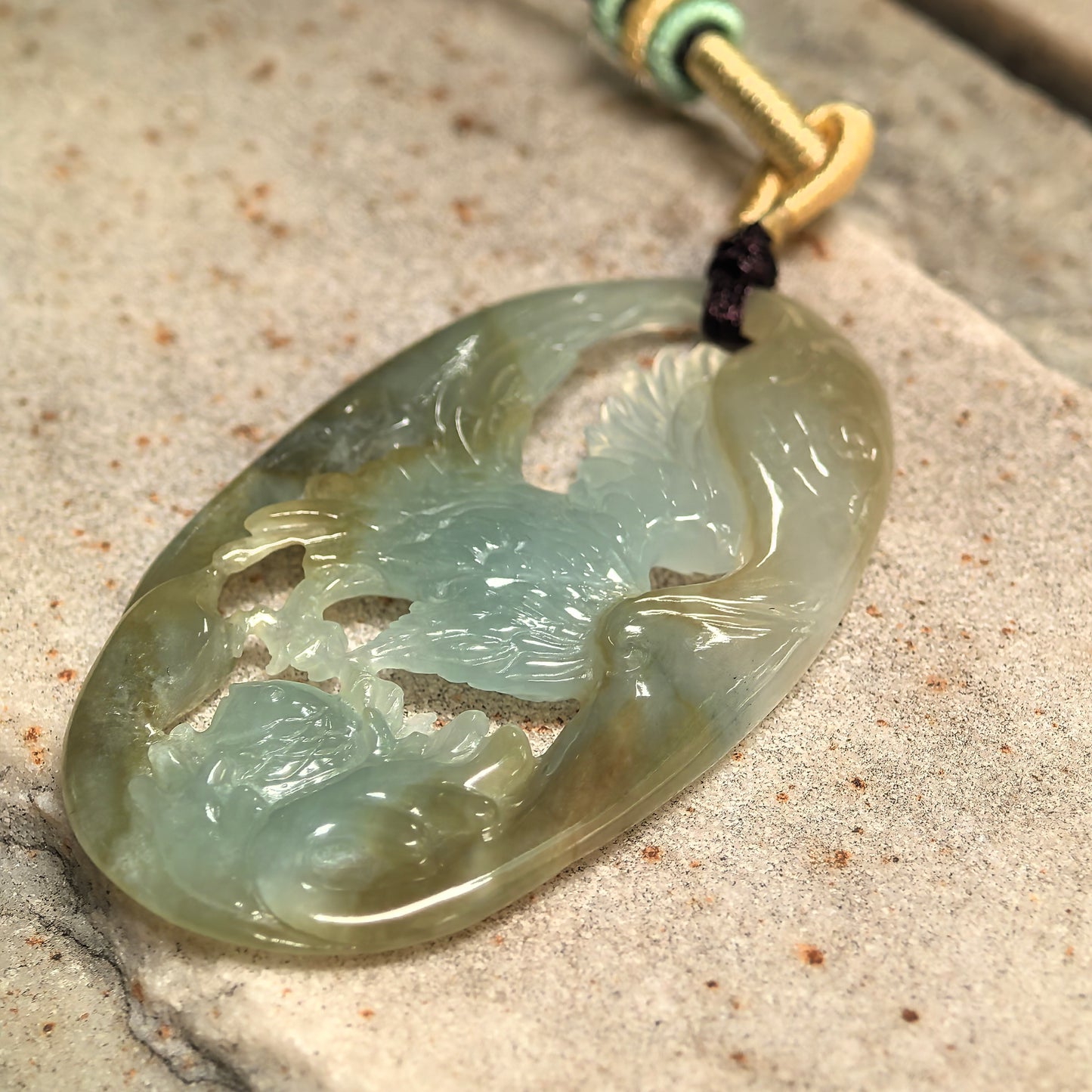 Side view of natural jadeite eagle pendant showing approximately 5 mm thickness.
