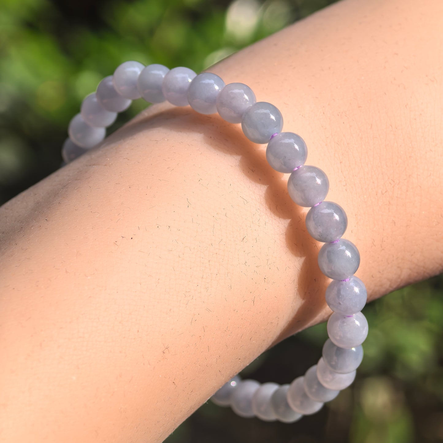 Glutinous-icy blue-purple jadeite bead bracelet showing soft translucency and natural internal patterns.