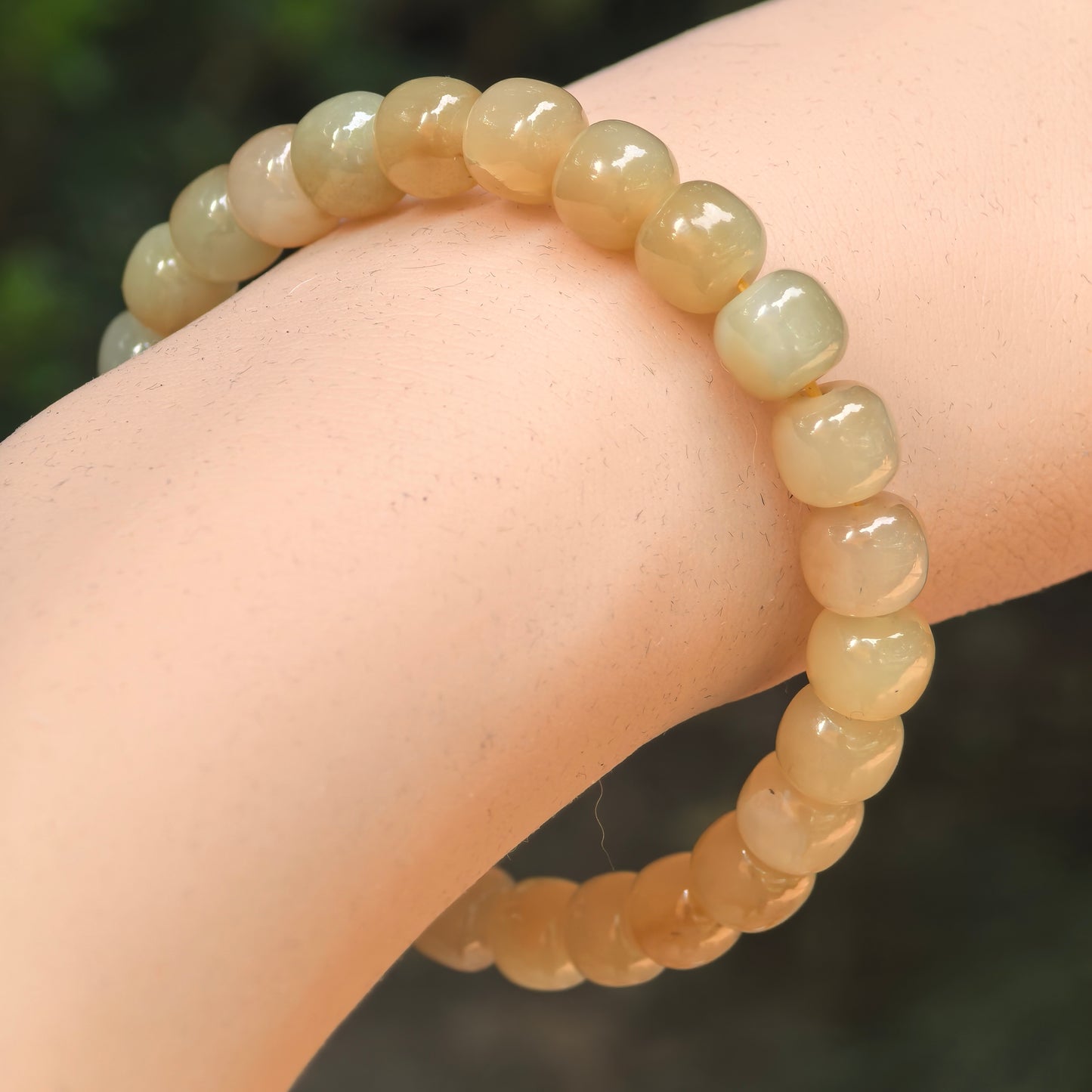 Natural sugar yellow Hetian jade abacus bead bracelet worn on wrist.