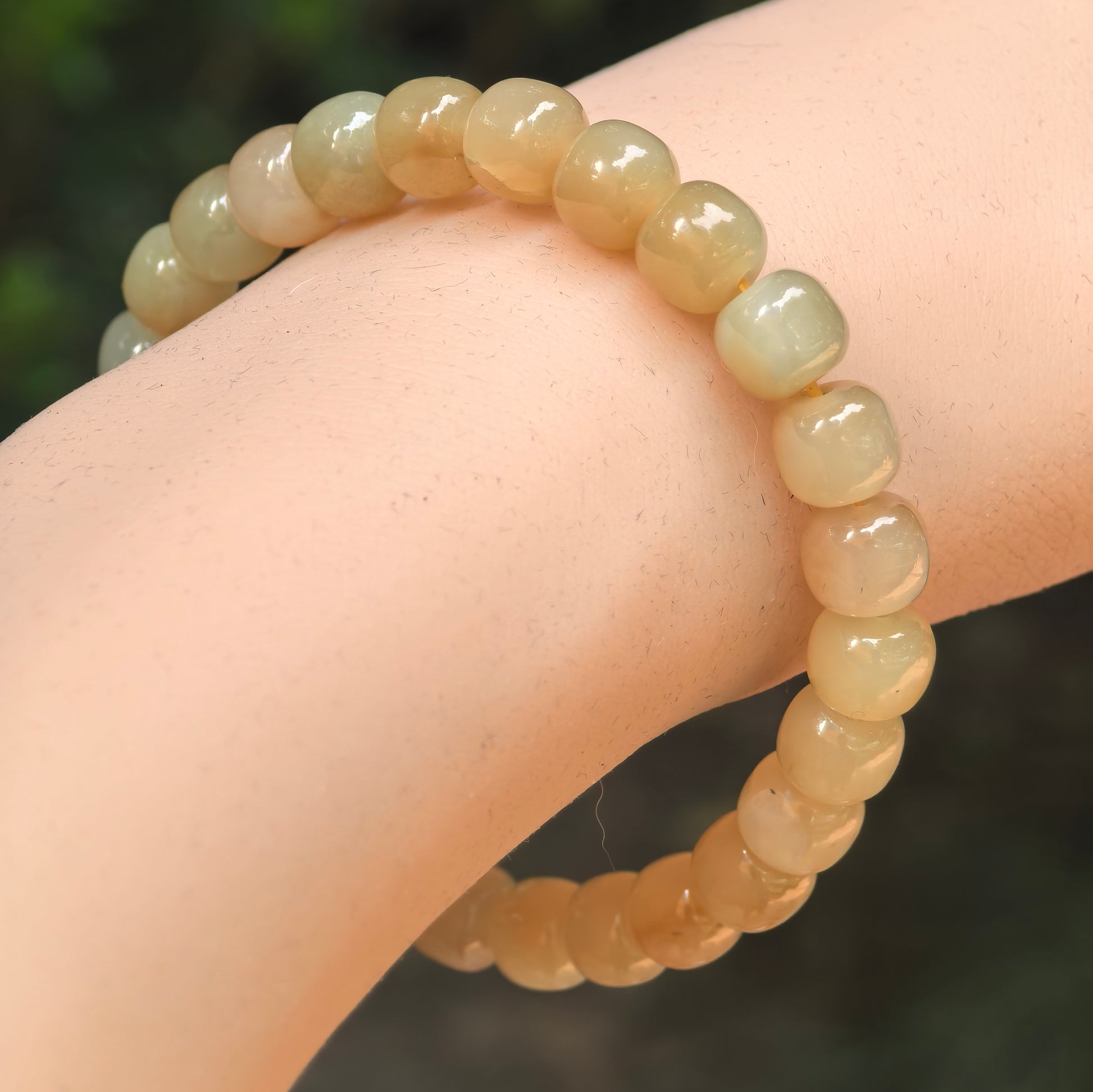 Natural sugar yellow Hetian jade abacus bead bracelet worn on wrist.