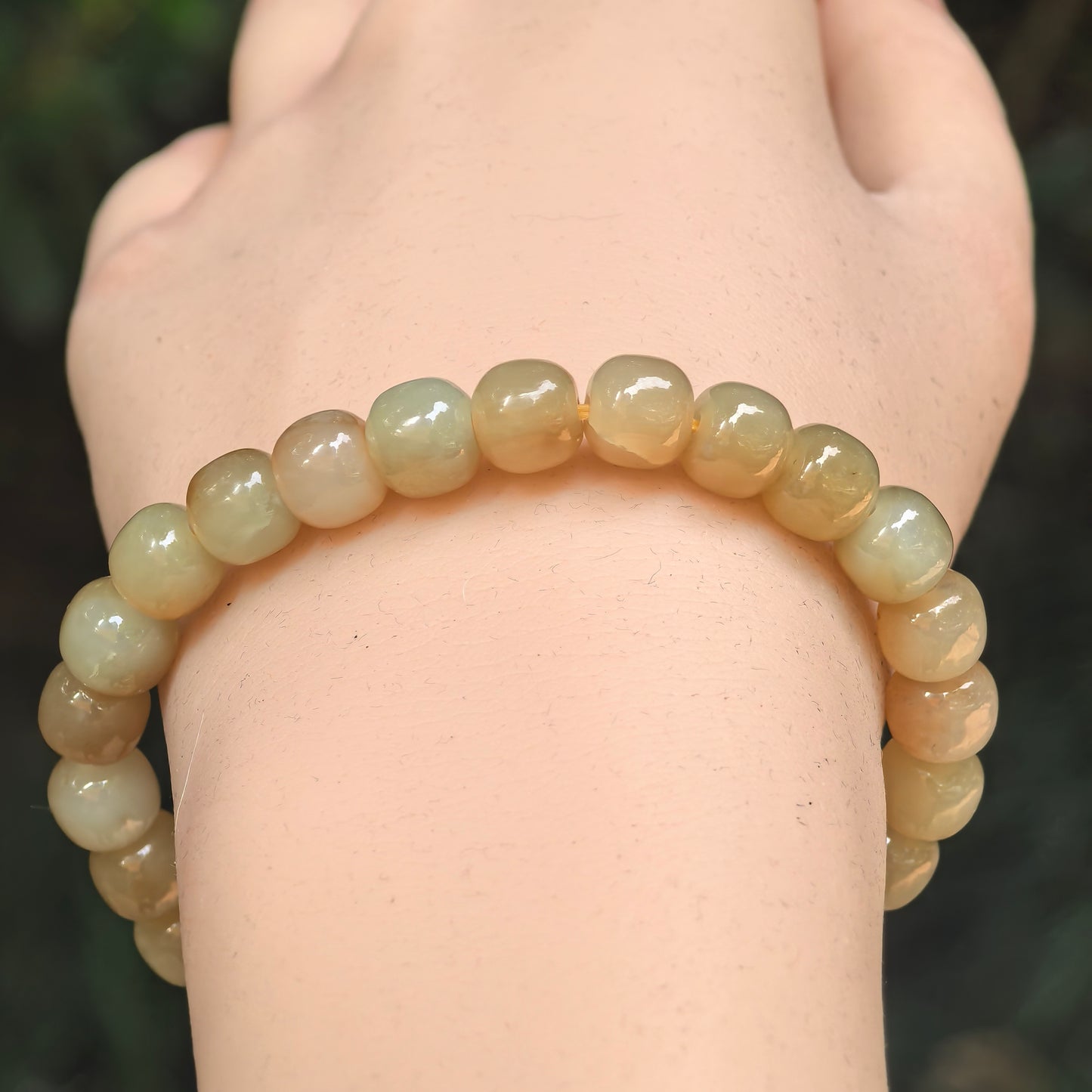 Close-up of sugar yellow nephrite abacus bead bracelet with glossy polished surface.