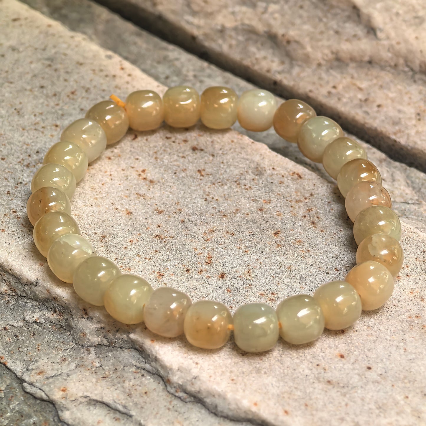 Sugar yellow nephrite elastic bead bracelet showing natural tonal variation.