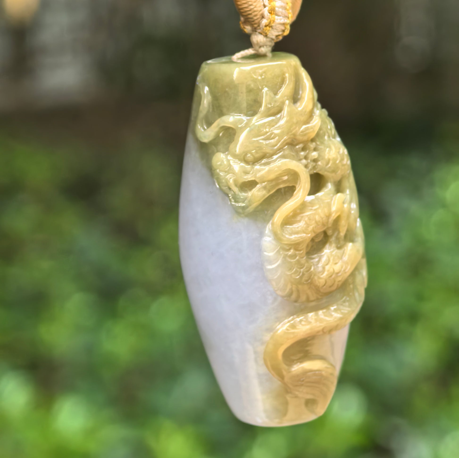 Natural Grade-A glutinous yellow dragon column jadeite pendant hanging on cord with raised dragon carving.