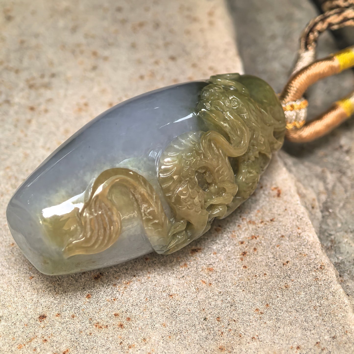 Side view of three-dimensional dragon column jadeite pendant showing thick structure and carved relief details.