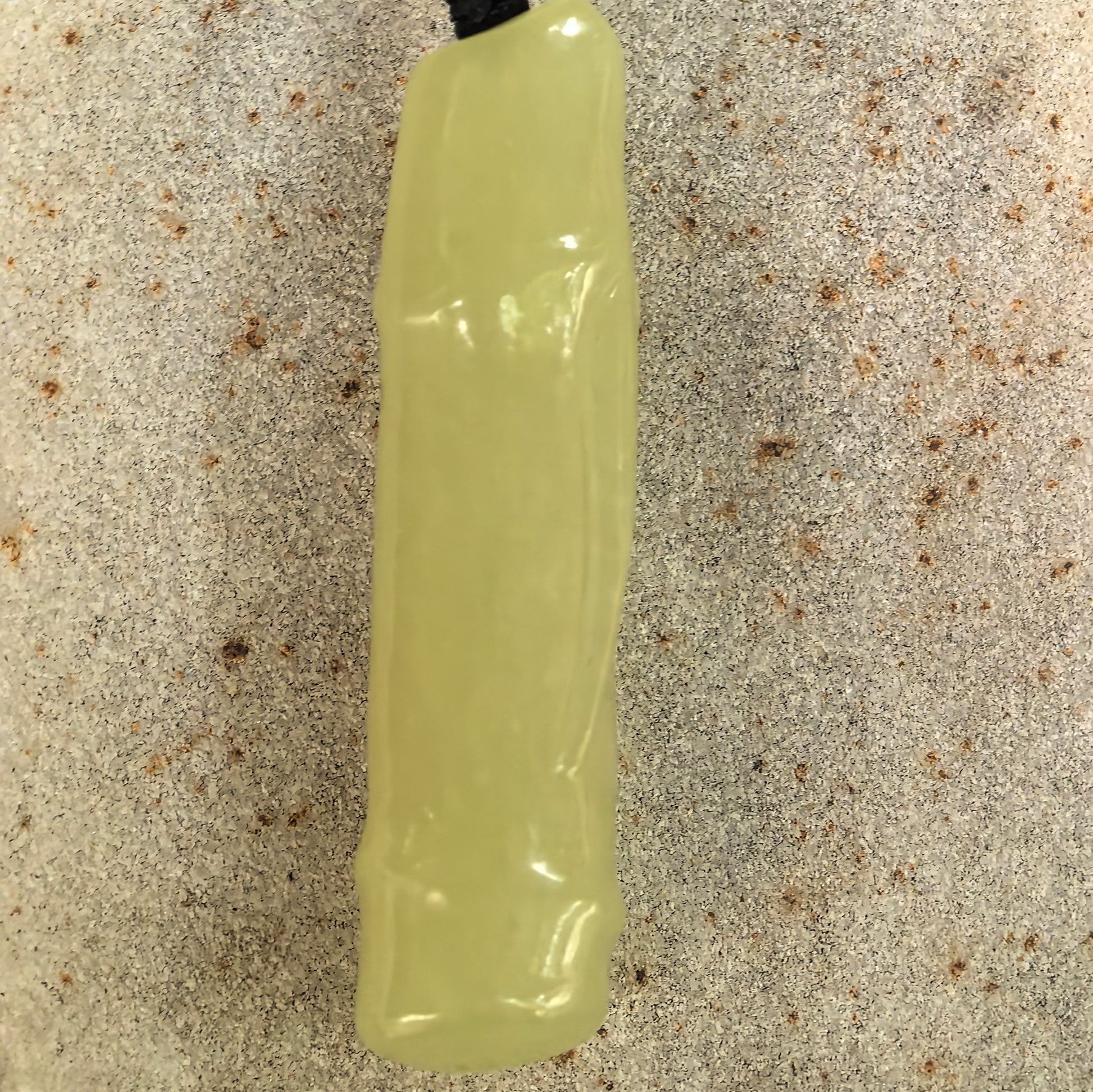 Close-up of carved Hetian jade bamboo section pendant showing smooth polished surface.