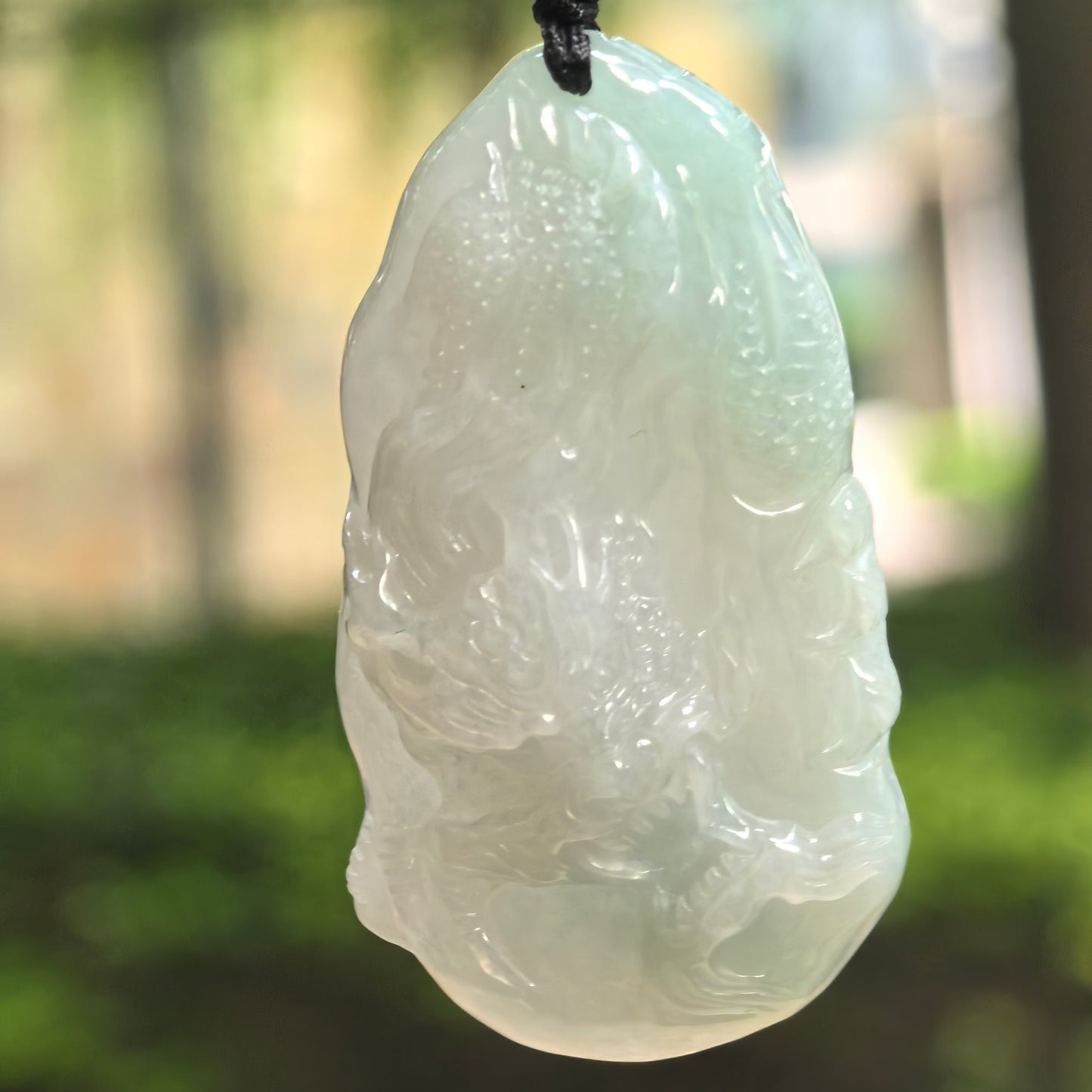 Natural Grade-A glutinous pale green jadeite dragon pendant hanging on cord.