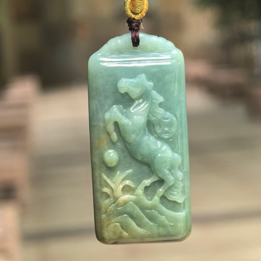 Natural Grade-A glutinous deep green horse jadeite pendant hanging on cord with rectangular carved form.