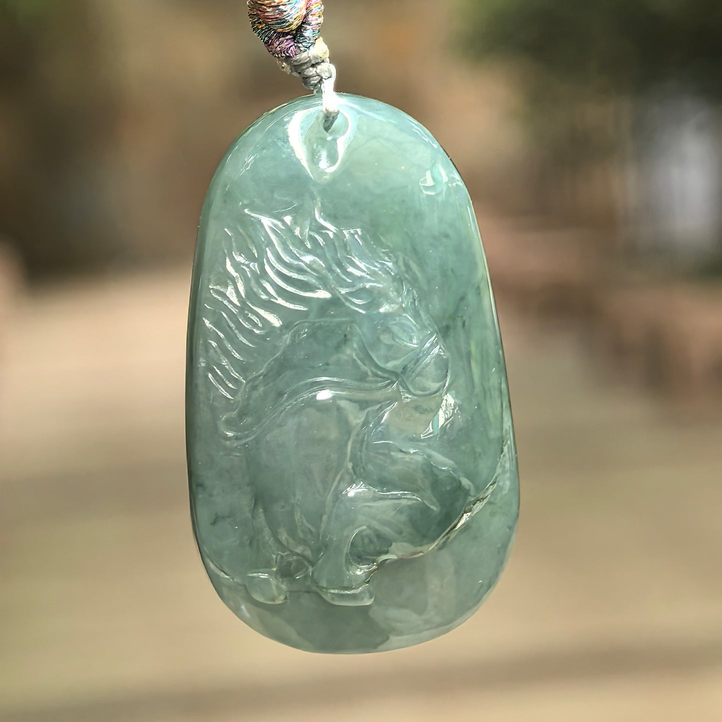Natural Grade-A glutinous deep green jadeite horse pendant hanging on cord.