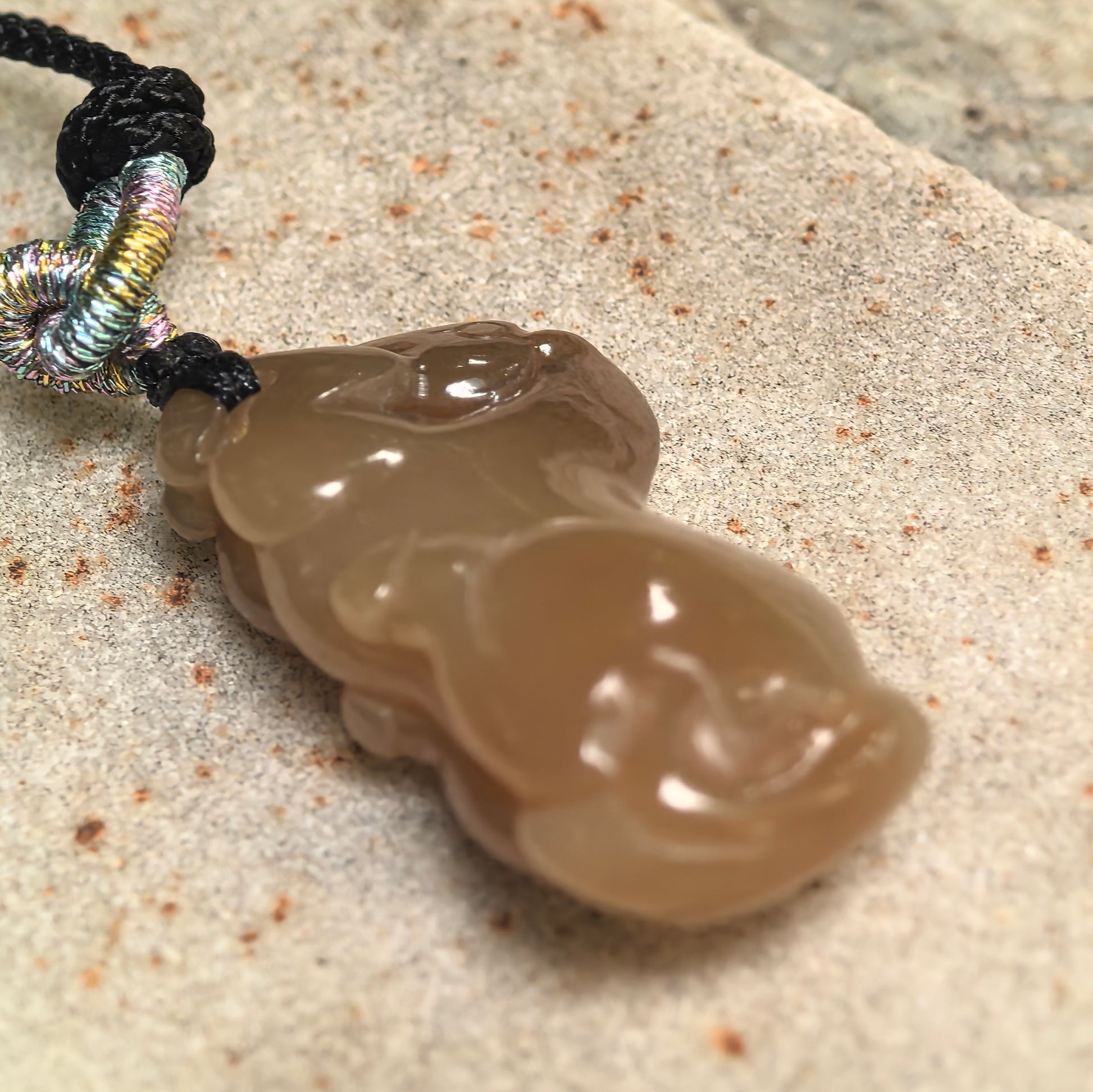 Side view of 3D carved Hetian jade horse pendant showing sculptural thickness and smooth curves.