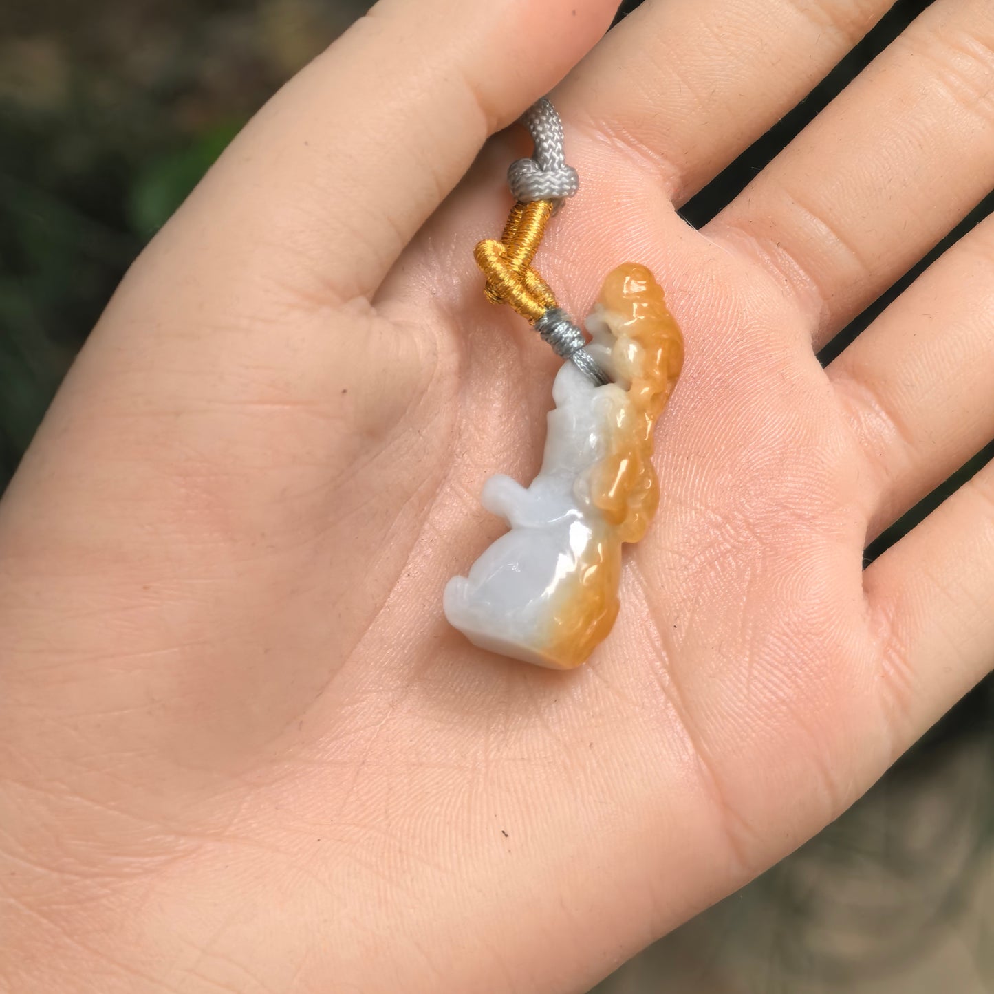 Small white jadeite elephant pendant with warm yellow skin and monkey riding elephant carving.