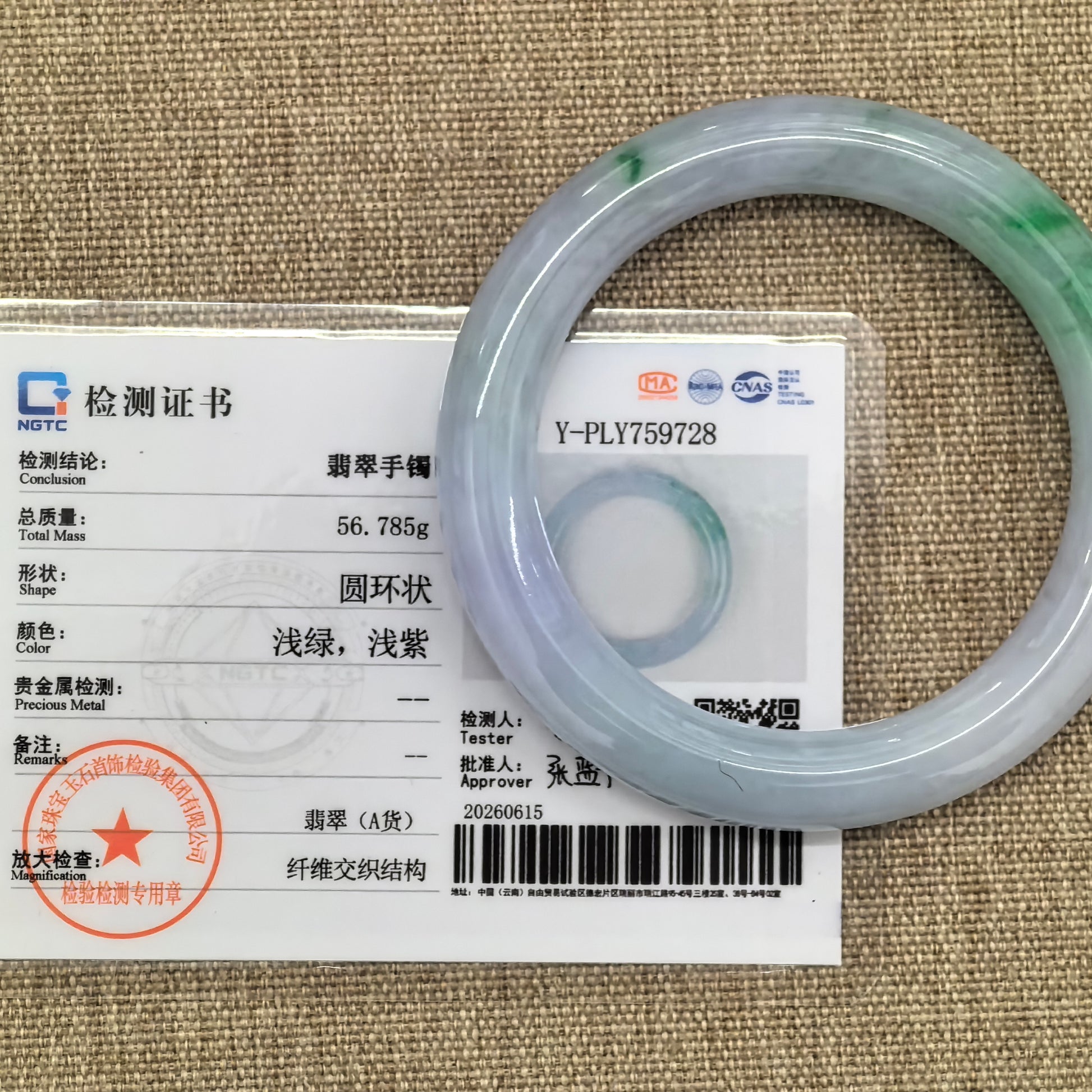 Jadeite bangle placed beside NGTC certificate showing authentication details and weight information.
