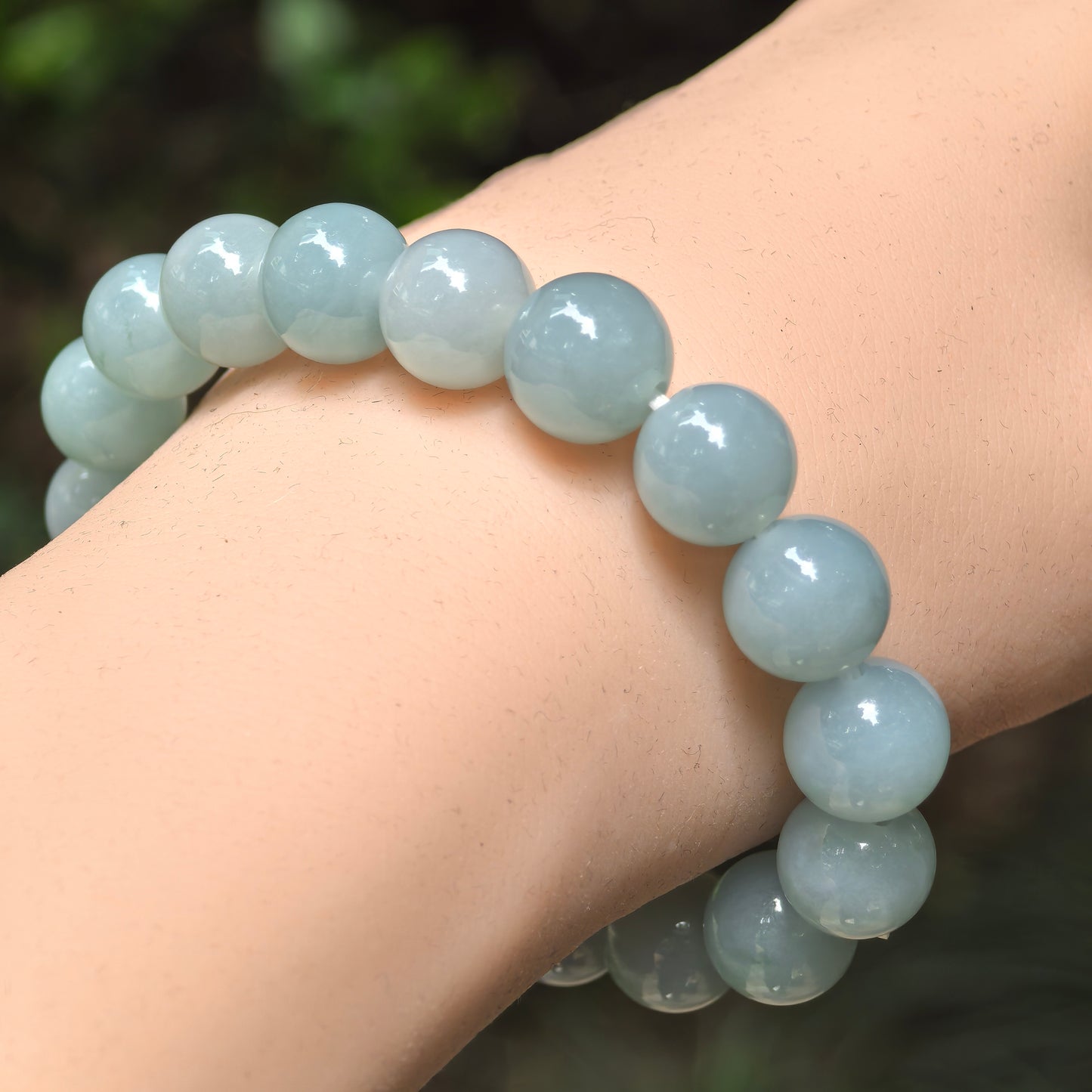 Natural Grade-A glutinous-icy green jadeite bead bracelet worn on the wrist.