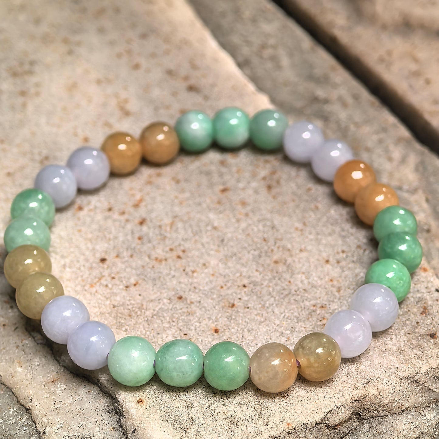 Glutinous jadeite bracelet with glossy round beads and natural color variation.