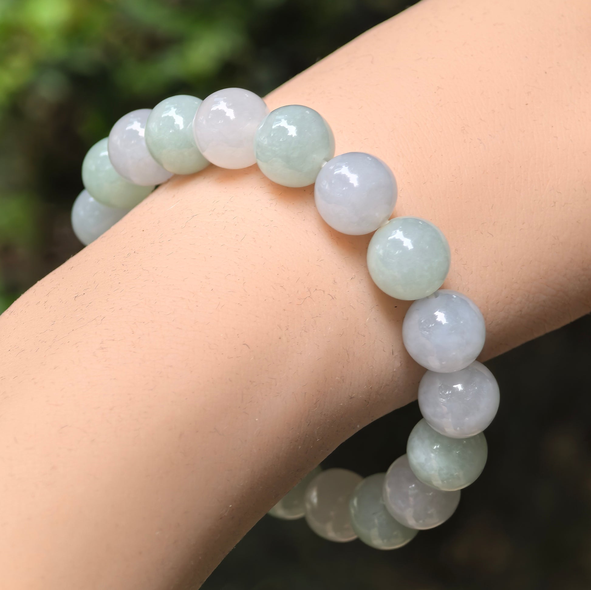 Natural Grade-A glutinous-icy pale green and lavender jadeite bead bracelet worn on the wrist.