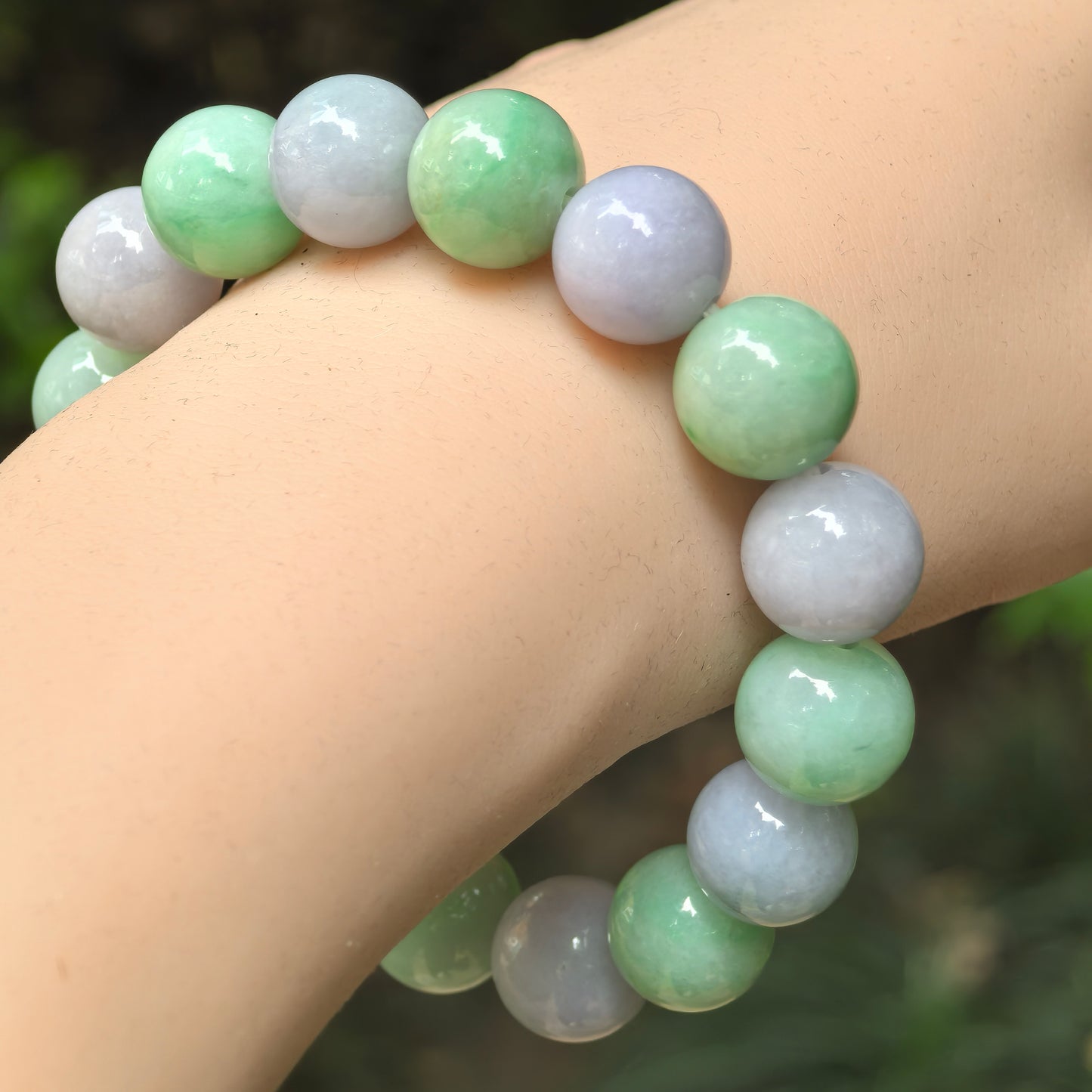 Natural Grade-A glutinous purple and green jadeite bead bracelet worn on wrist.