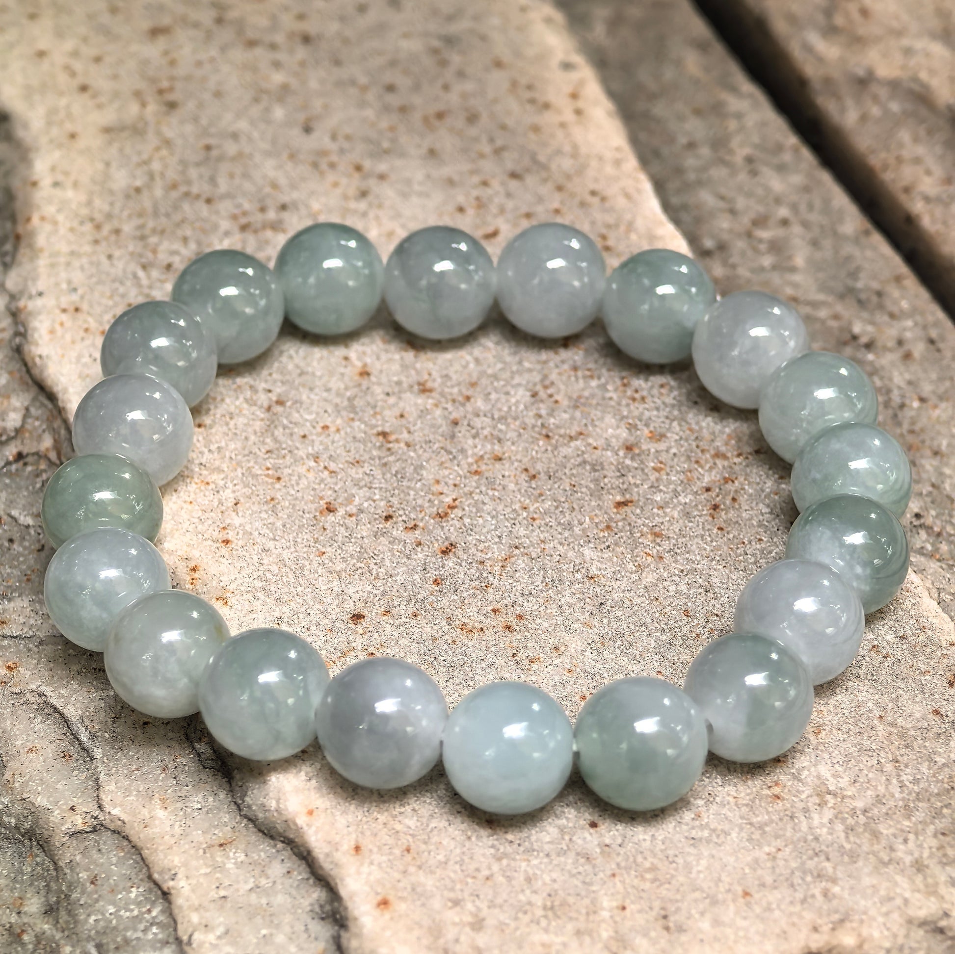 Natural jadeite bracelet showing subtle pale green color variation between beads.