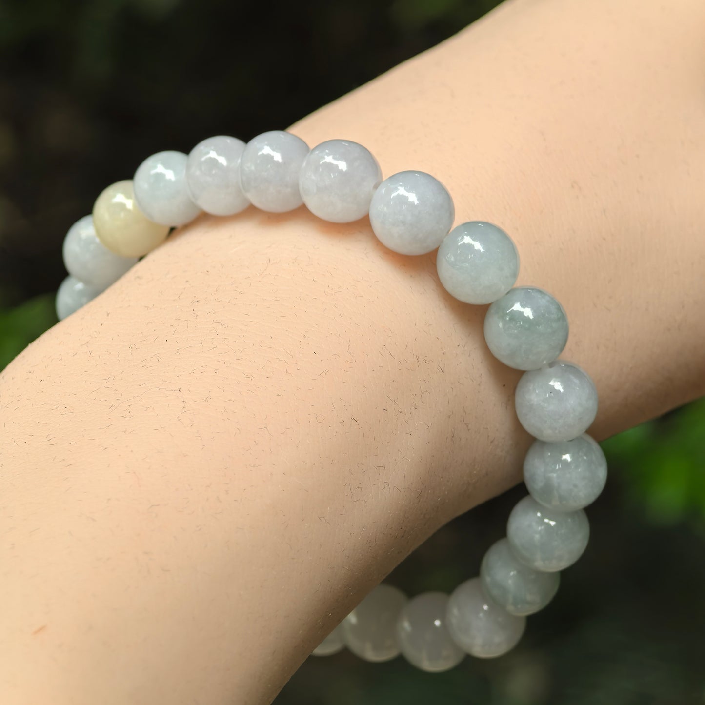 Natural Grade-A glutinous pale green jadeite bead bracelet worn on the wrist.
