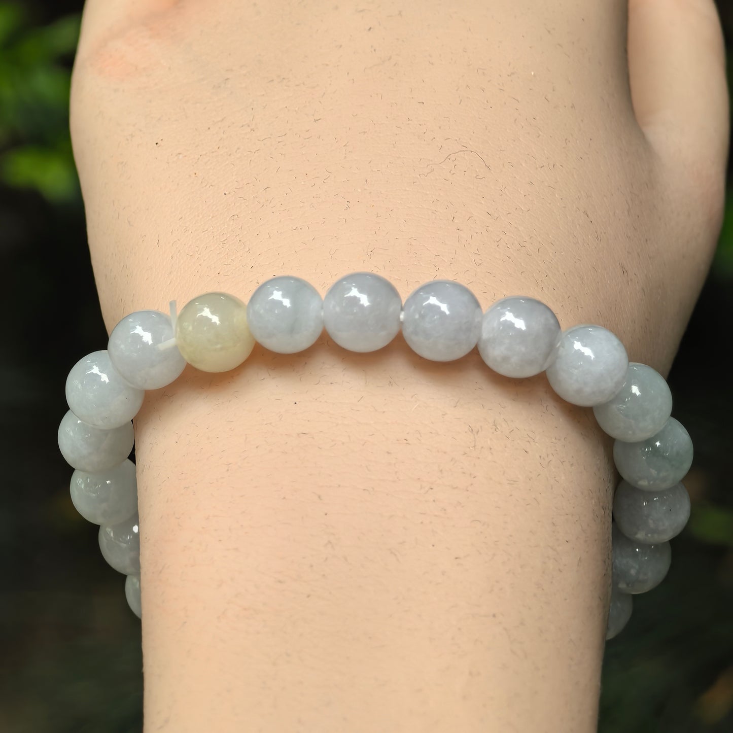 Close-up of pale green jadeite round beads with soft glossy luster.