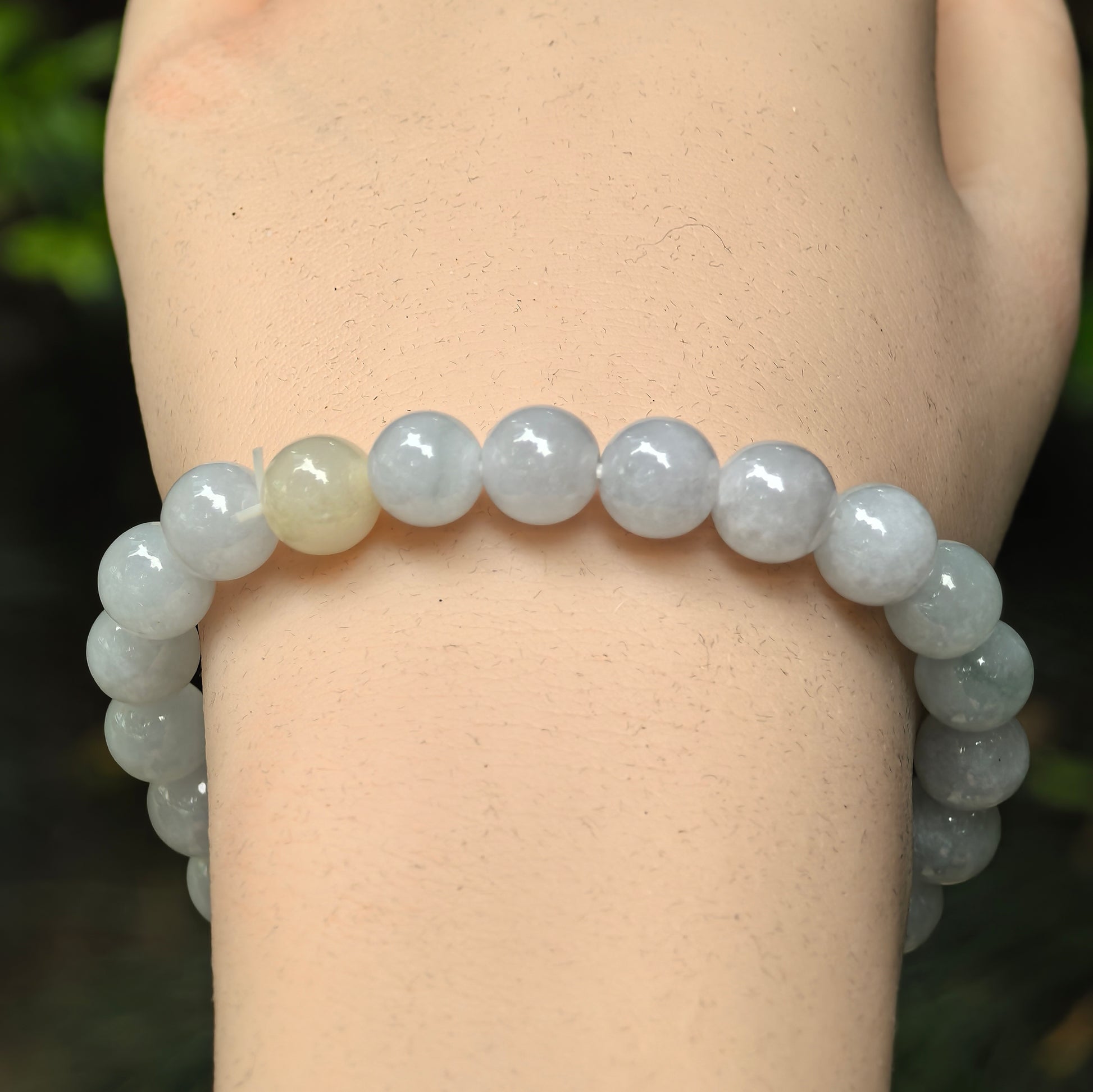 Close-up of pale green jadeite round beads with soft glossy luster.