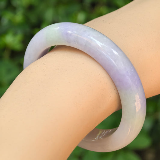 Natural Grade-A glutinous purple green D-shape jadeite bangle worn on the wrist.
