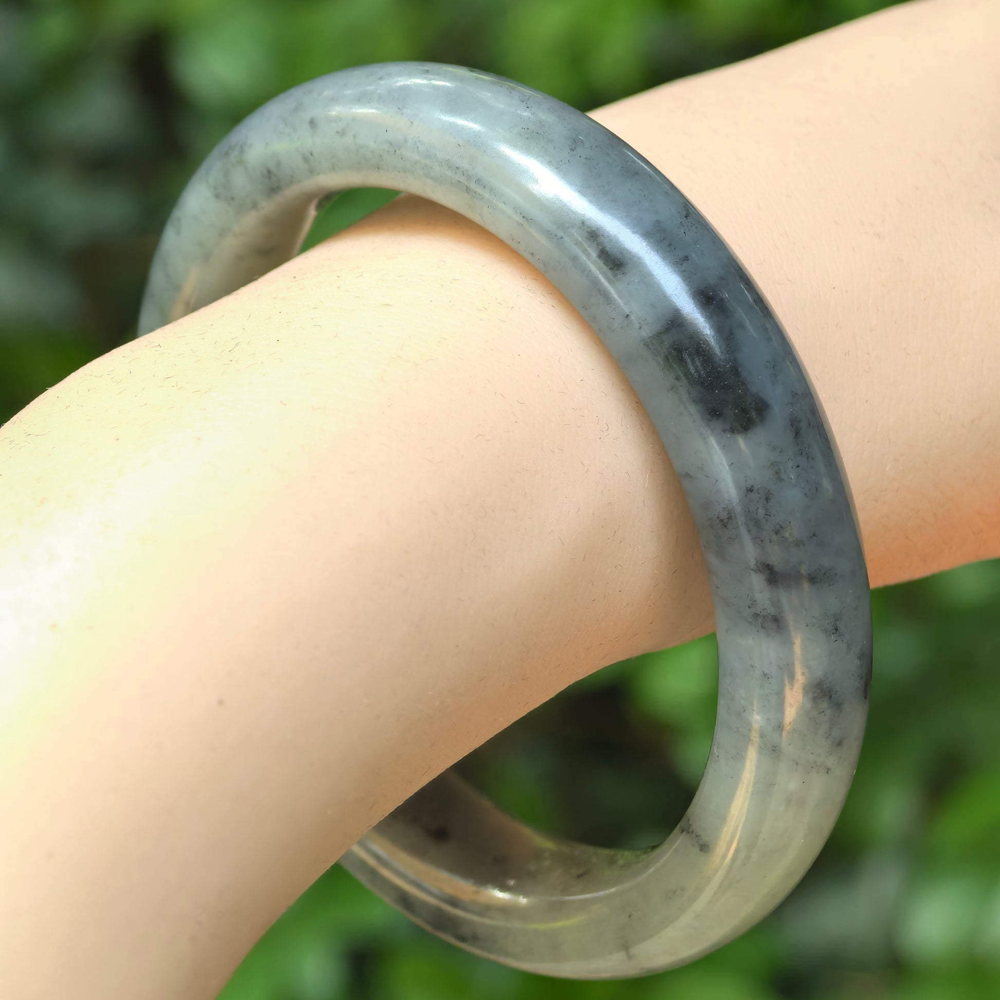Natural Hetian jade ink-wash D-shape bangle worn on the wrist.
