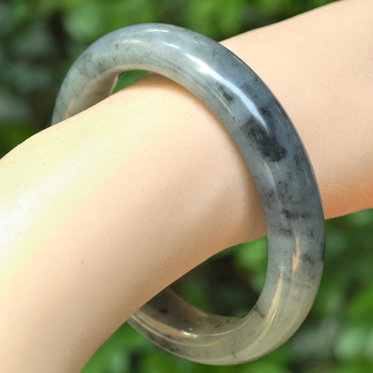 Natural Hetian jade ink-wash D-shape bangle worn on the wrist.
