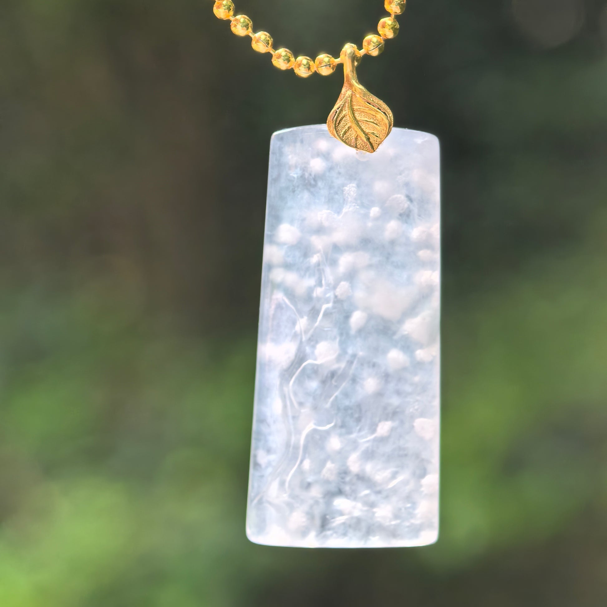Natural Grade-A icy snowflake cotton jadeite pendant with 18K gold setting.
