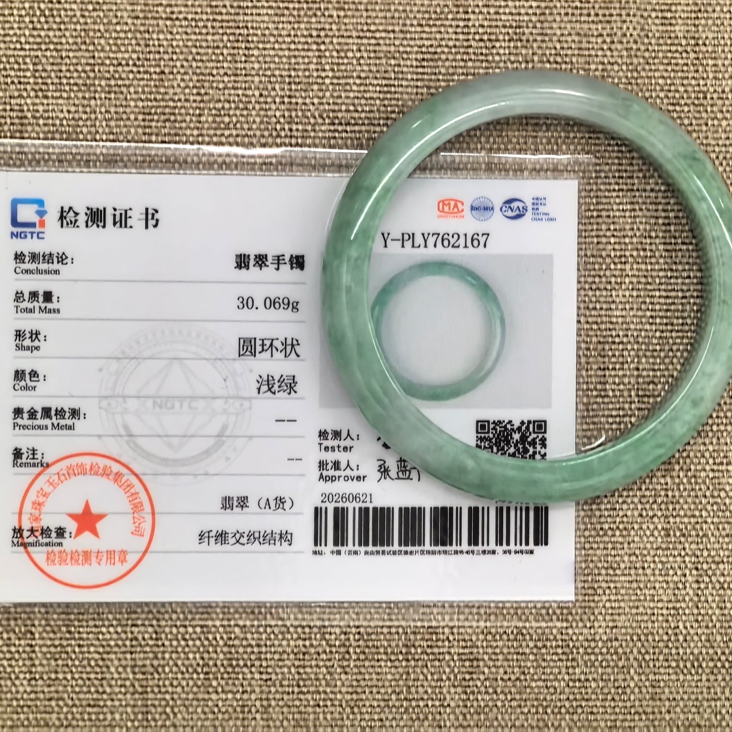 NGTC-certified natural Grade-A green jadeite bangle displayed with matching certificate.