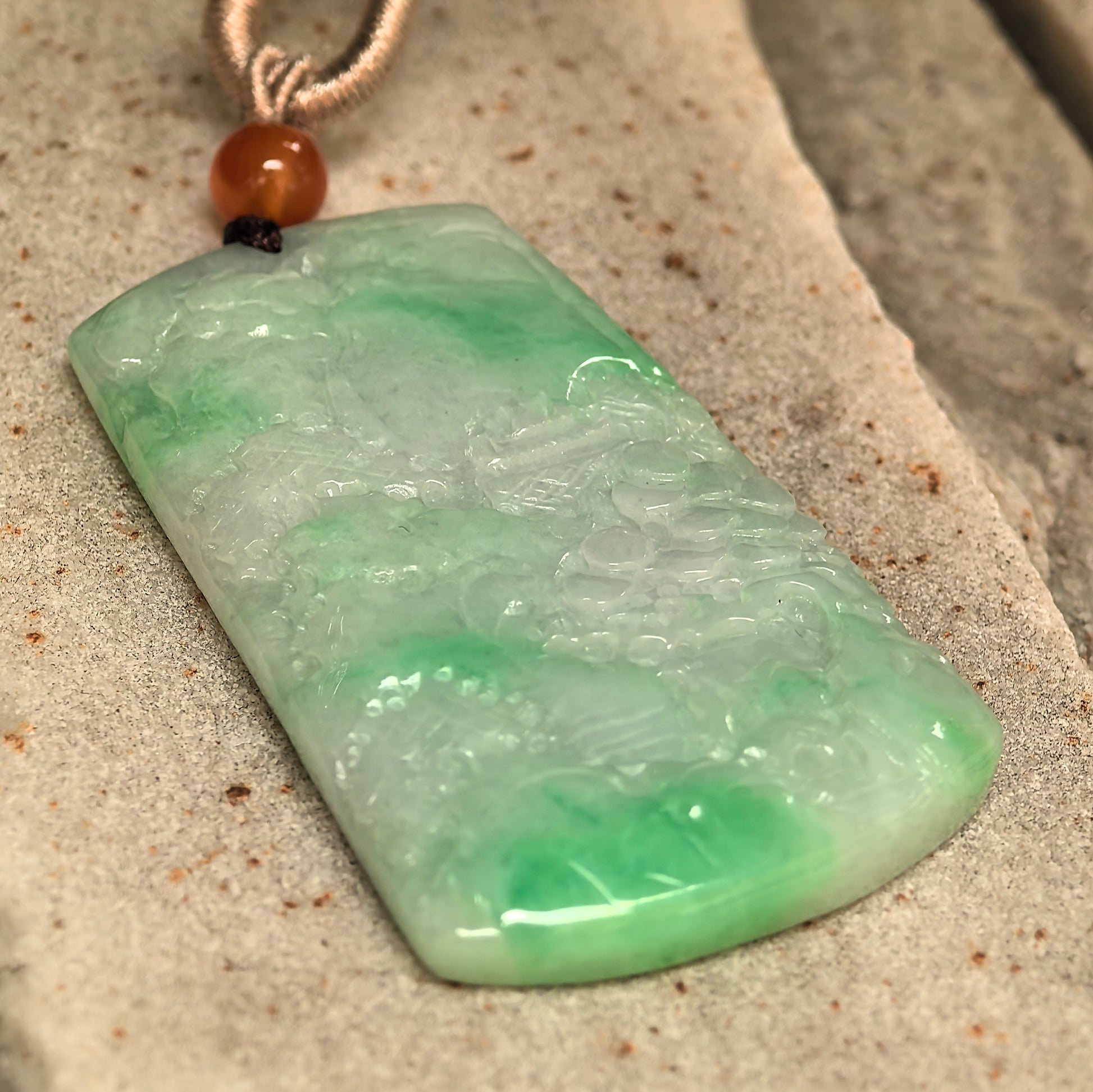 Carved green jadeite plaque pendant with smooth luster and vivid natural color.
