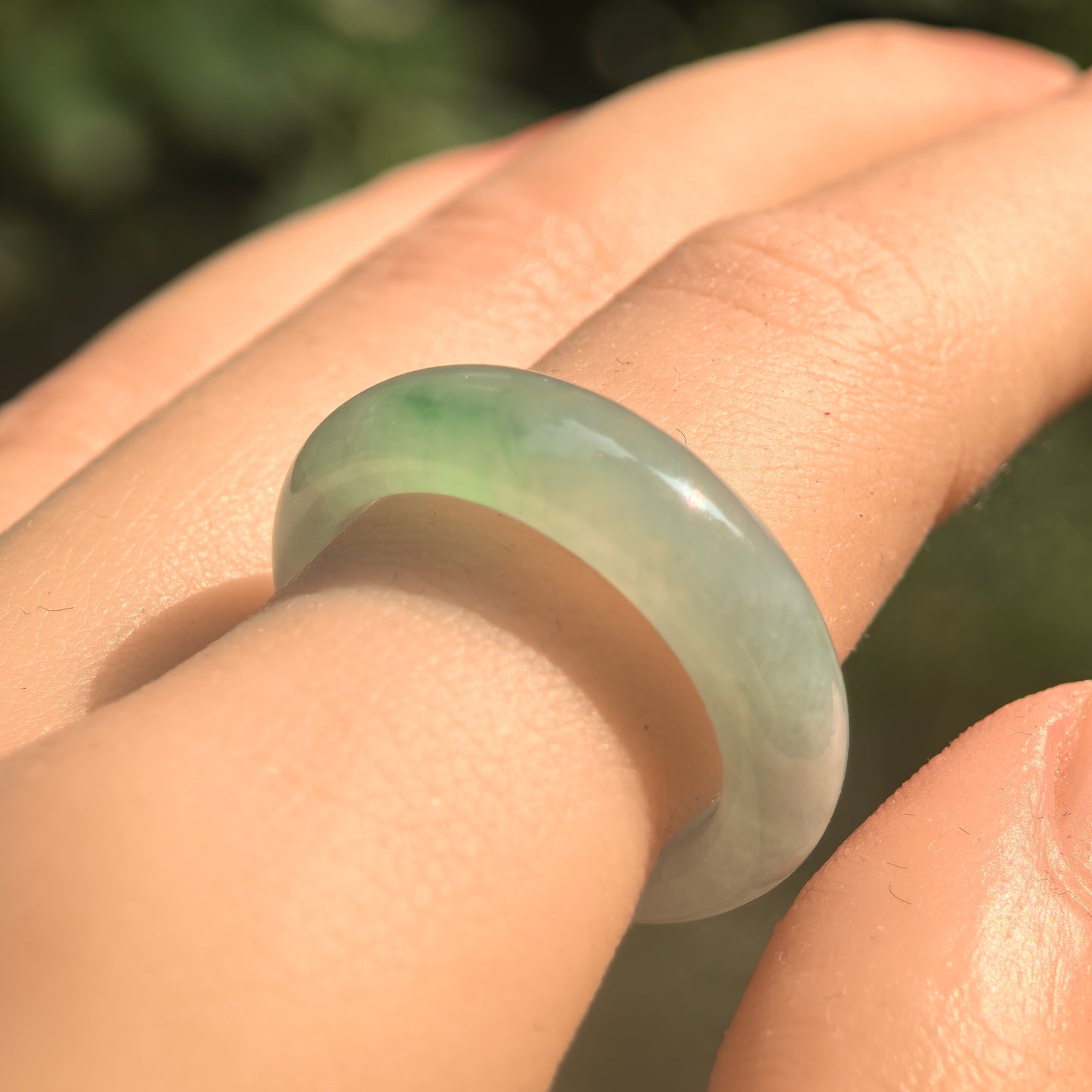 Natural Grade-A jadeite ring band under sunlight, showing icy glutinous texture and gentle green glow.
