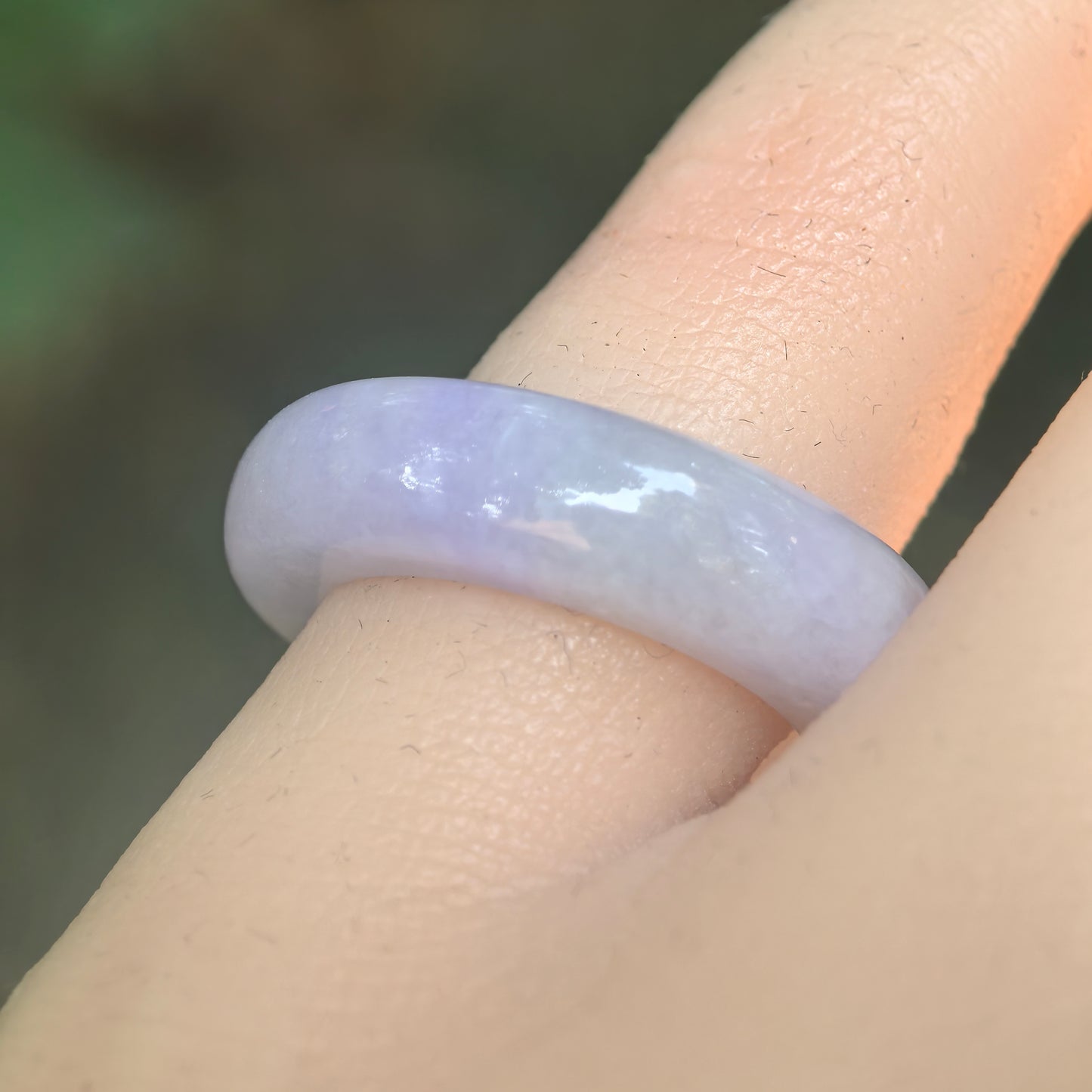 Natural Grade-A glutinous lavender jadeite ring band worn on finger under natural light.
