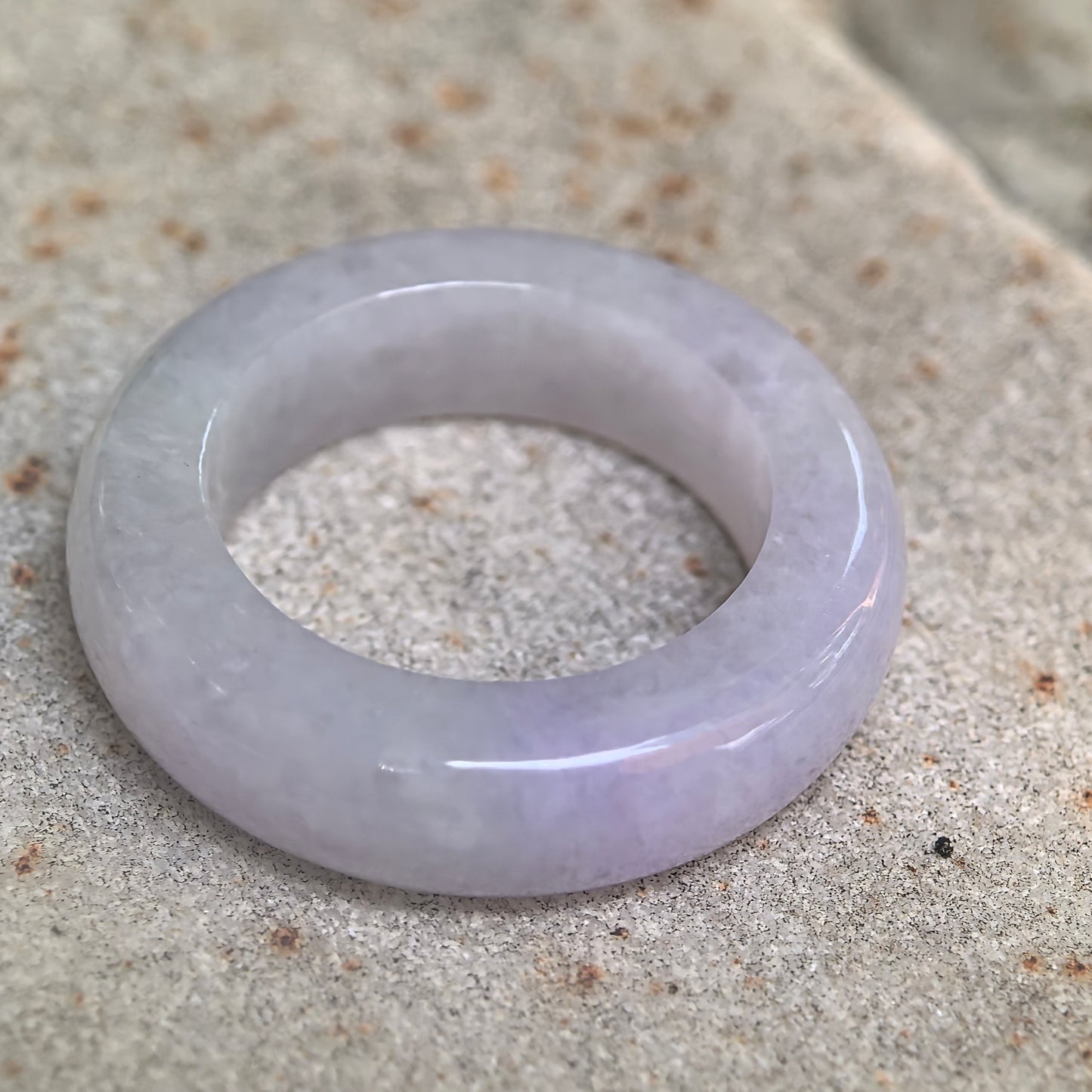 Side view of glutinous lavender jadeite ring band showing medium width and comfortable profile.
