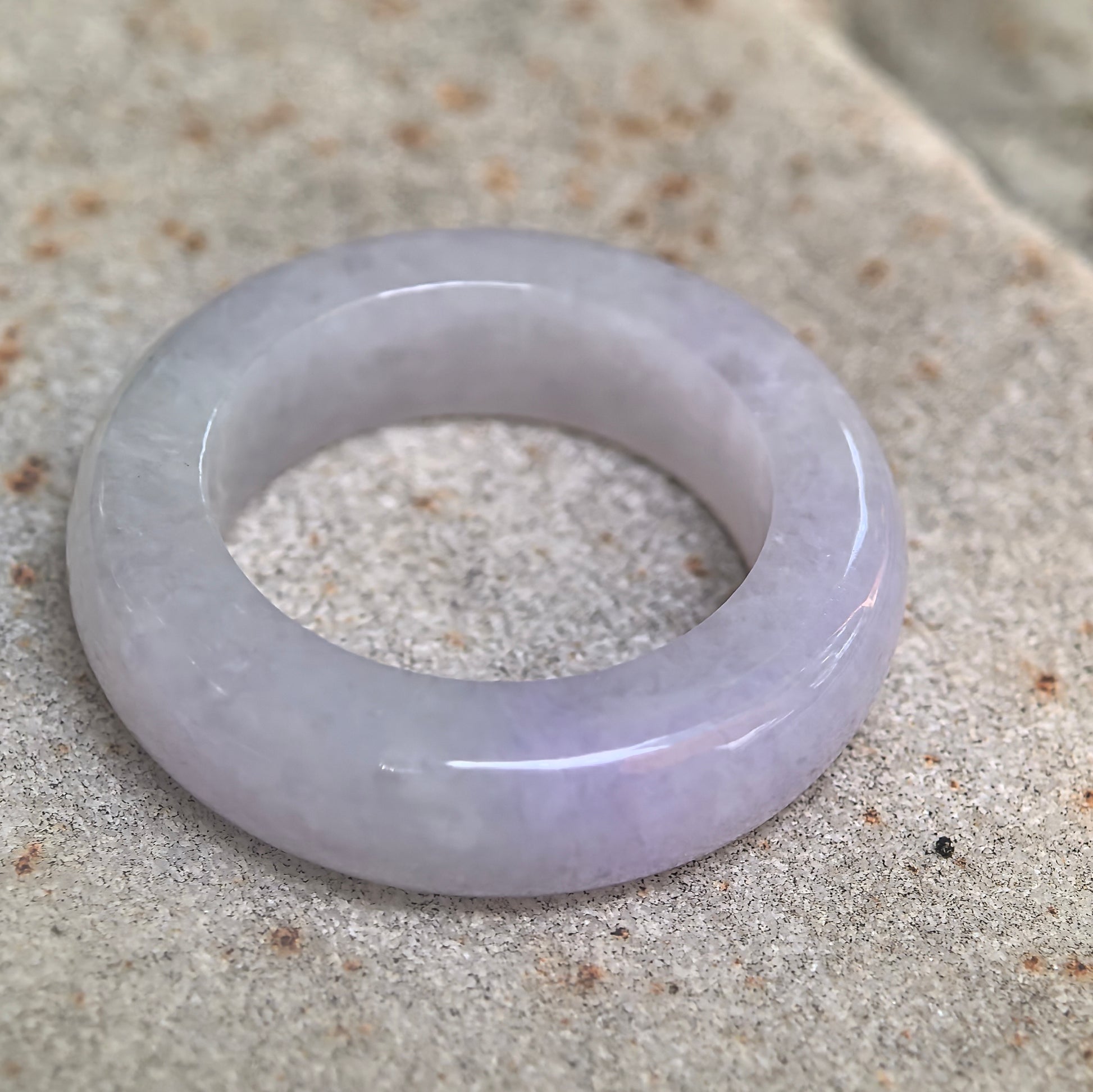 Side view of glutinous lavender jadeite ring band showing medium width and comfortable profile.
