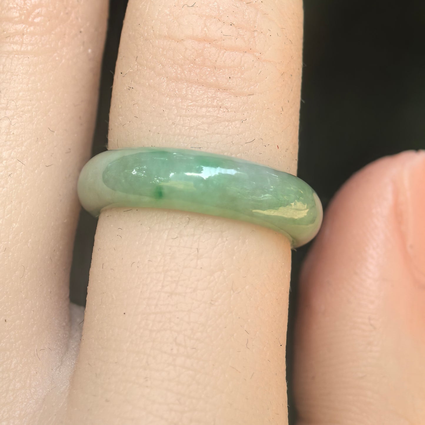 Close-up of light green jadeite ring band showing smooth polish and soft translucency.
