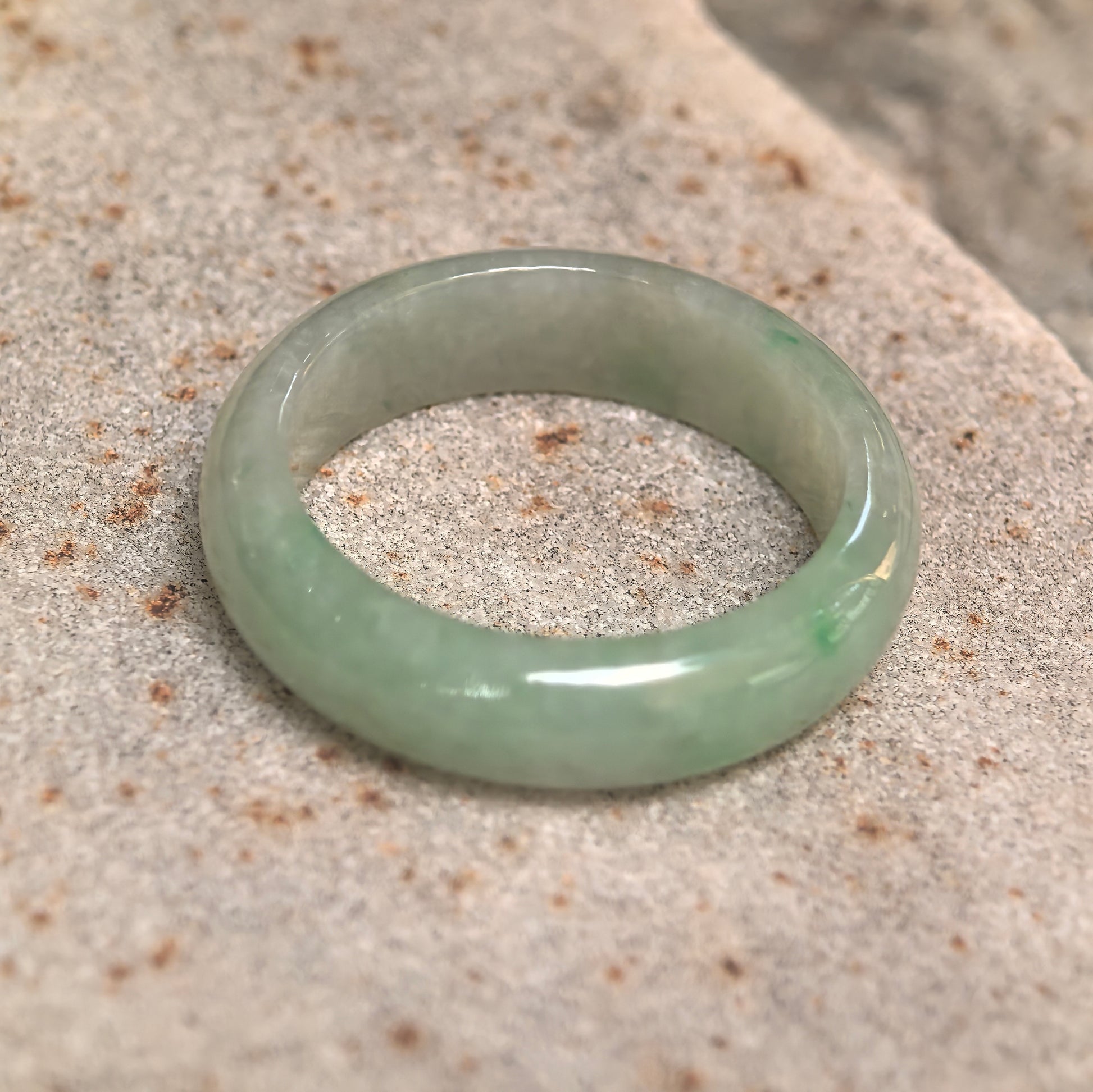Side view of natural jadeite ring band showing slim-to-medium profile and smooth luster.

