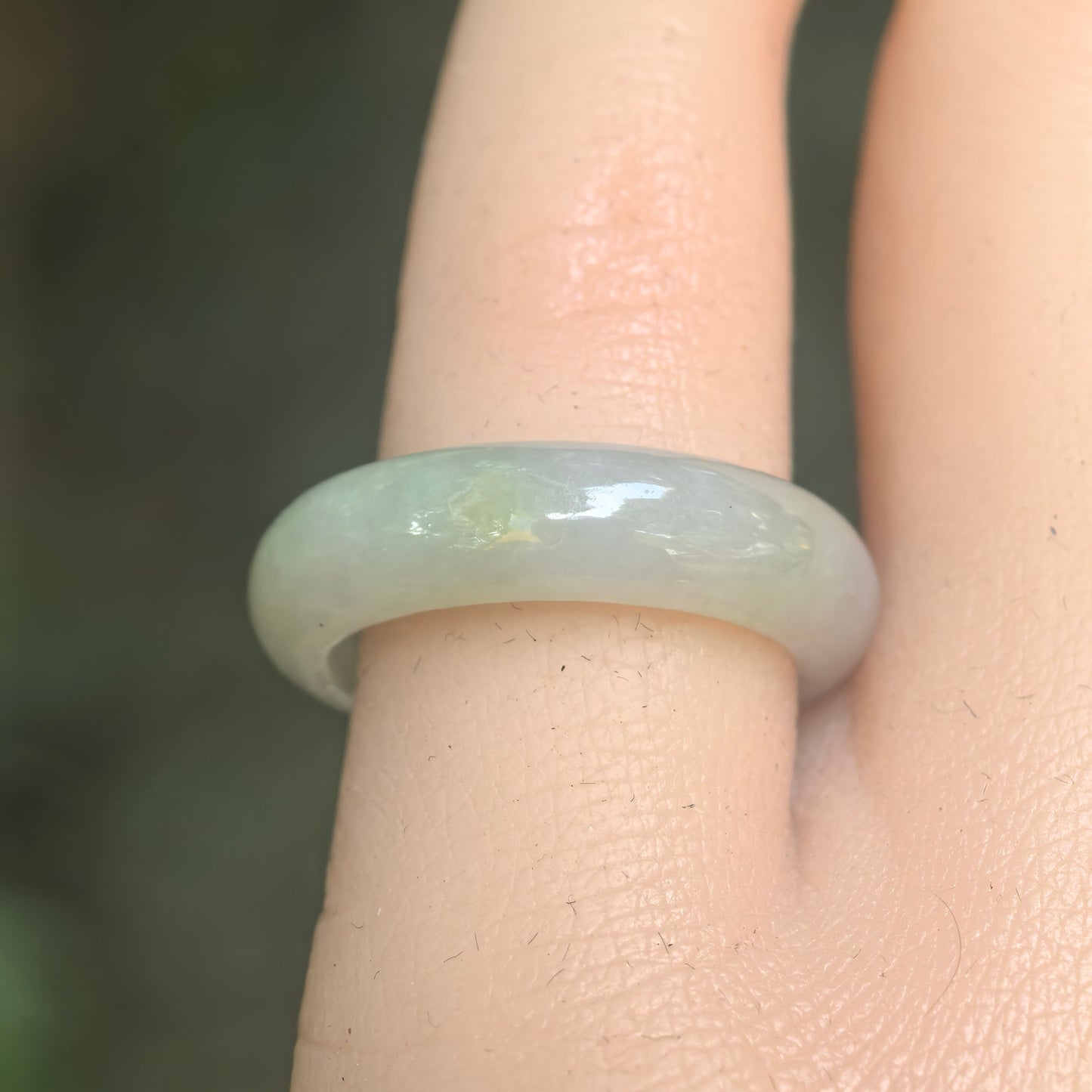 Close-up of light green jadeite ring band showing smooth polished surface and soft translucency.
