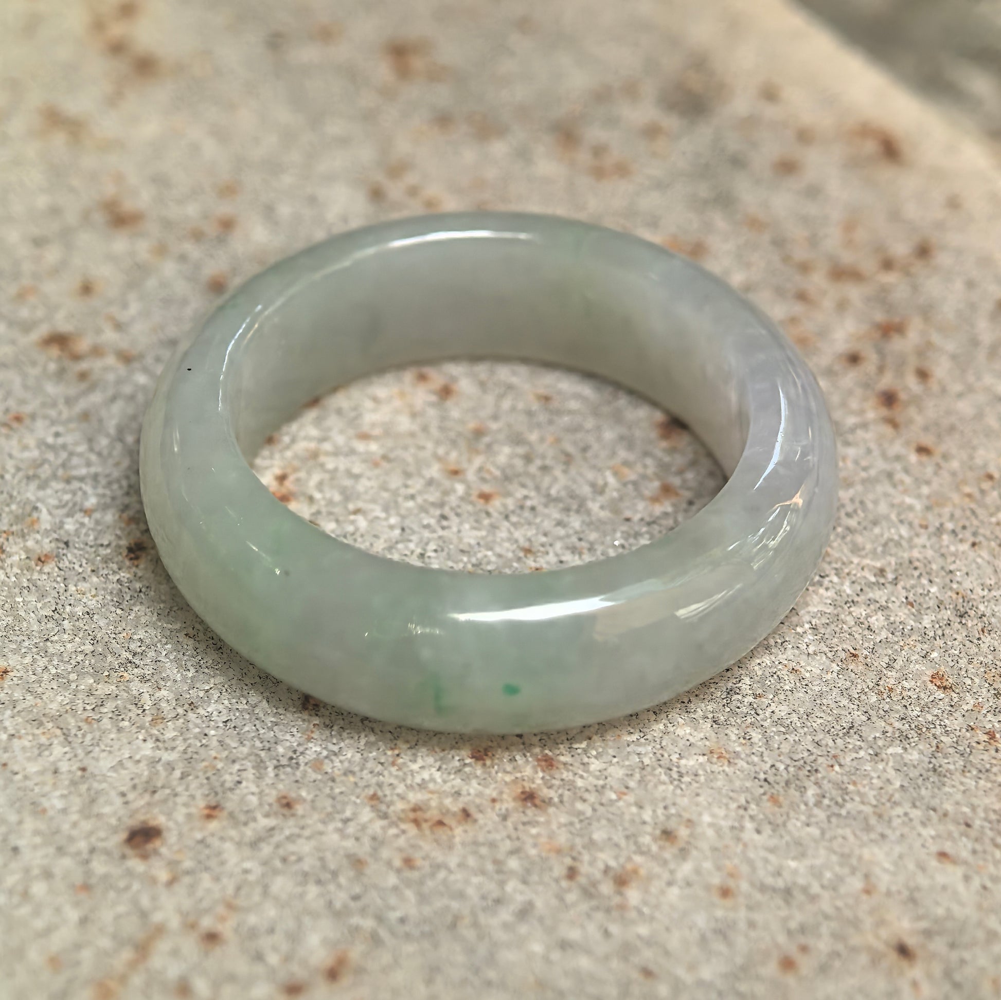 Side view of light green jadeite ring band showing medium width and comfortable rounded profile.
