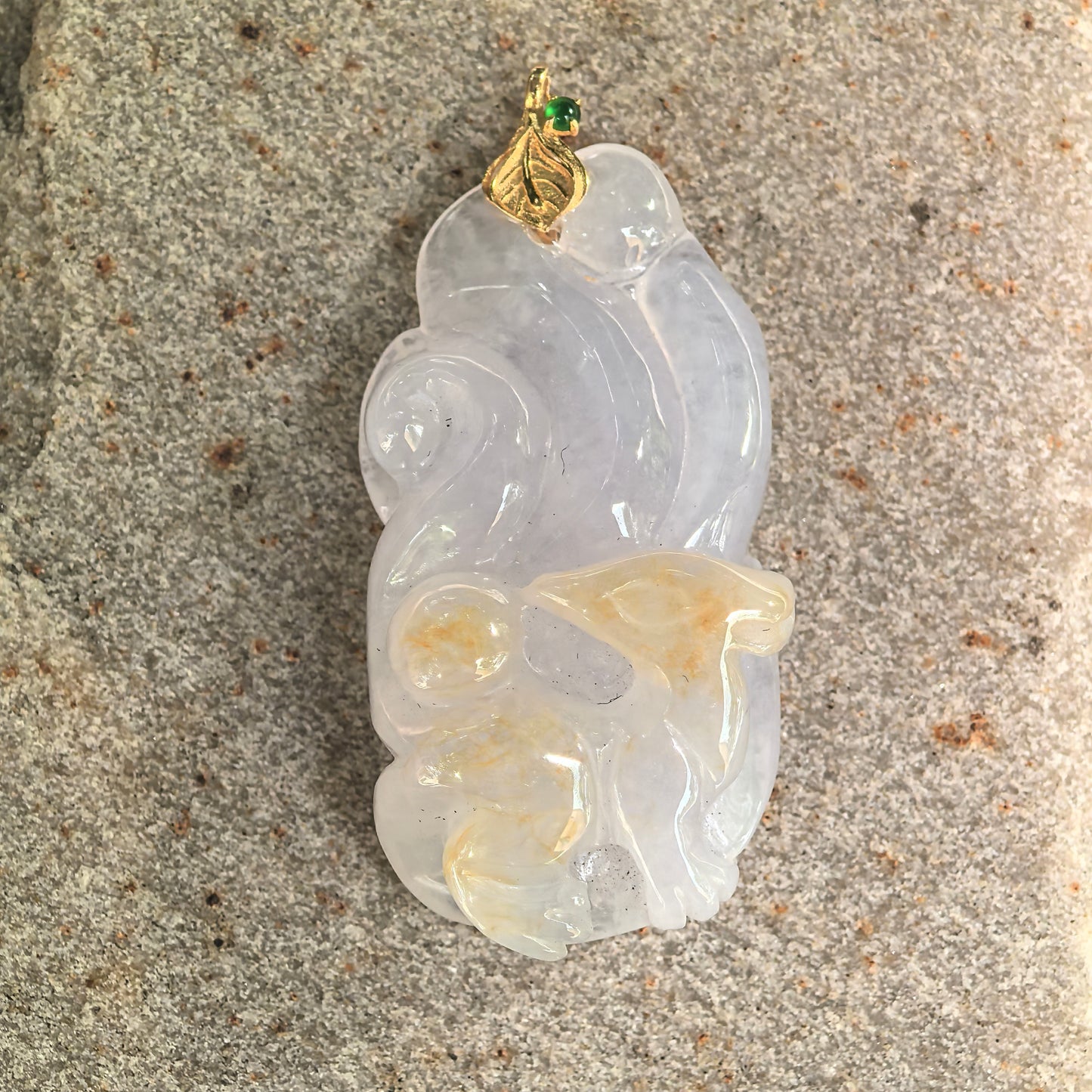 Close-up of carved nine-tailed fox jadeite pendant with 18K gold leaf-style bail.

