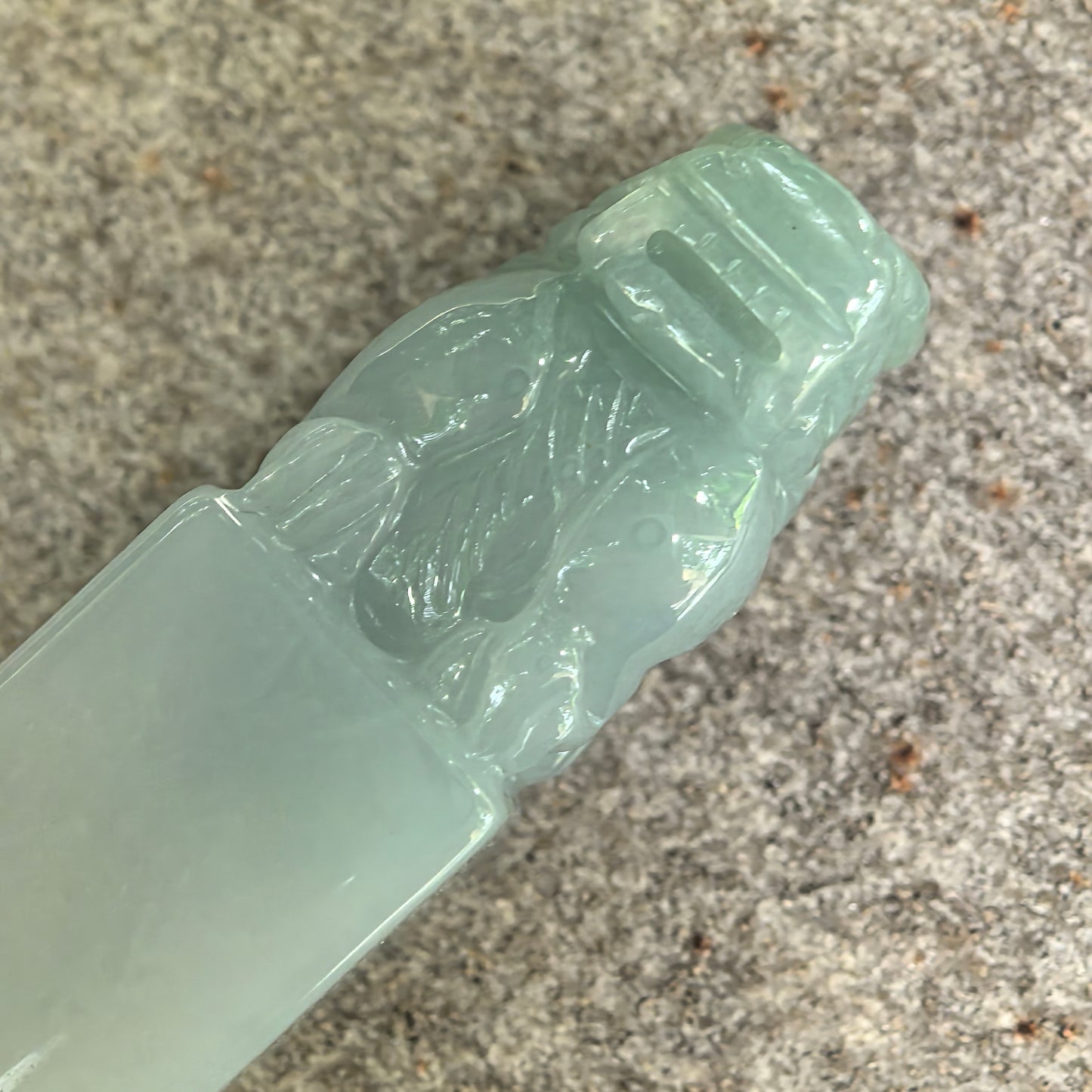 Detailed view of carved guardian lion on natural Grade-A light green jadeite ornament.
