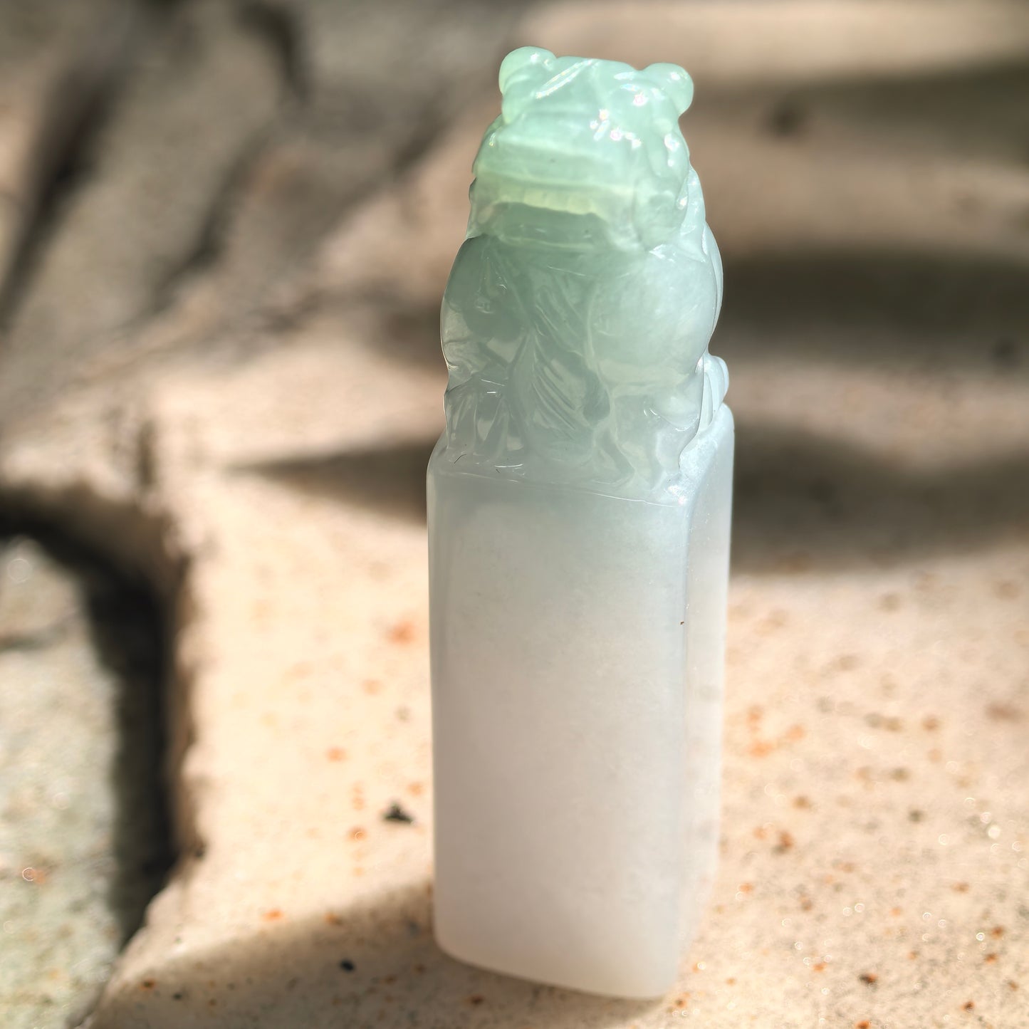 Natural jadeite lion seal ornament standing upright with glossy icy glutinous texture.
