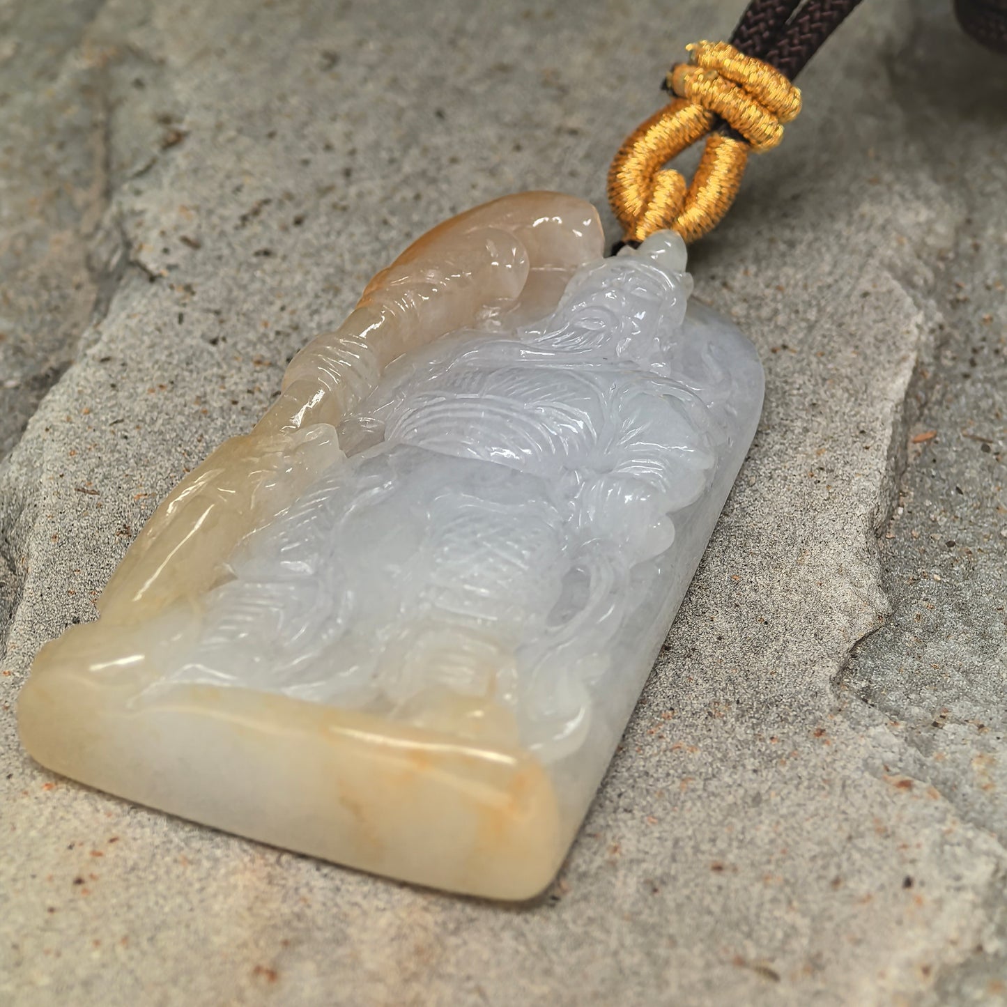 Detailed view of glutinous jadeite Guan Gong pendant showing robe, weapon, and polished luster.
