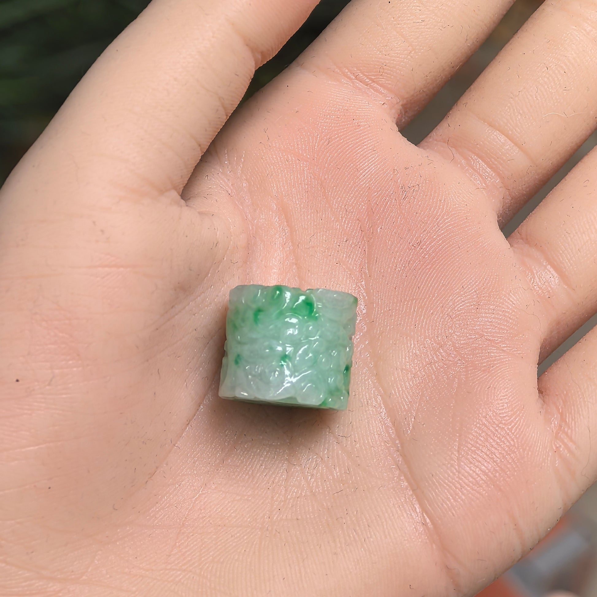 Natural Grade-A glutinous green-white jadeite carved barrel bead pendant shown on hand.
