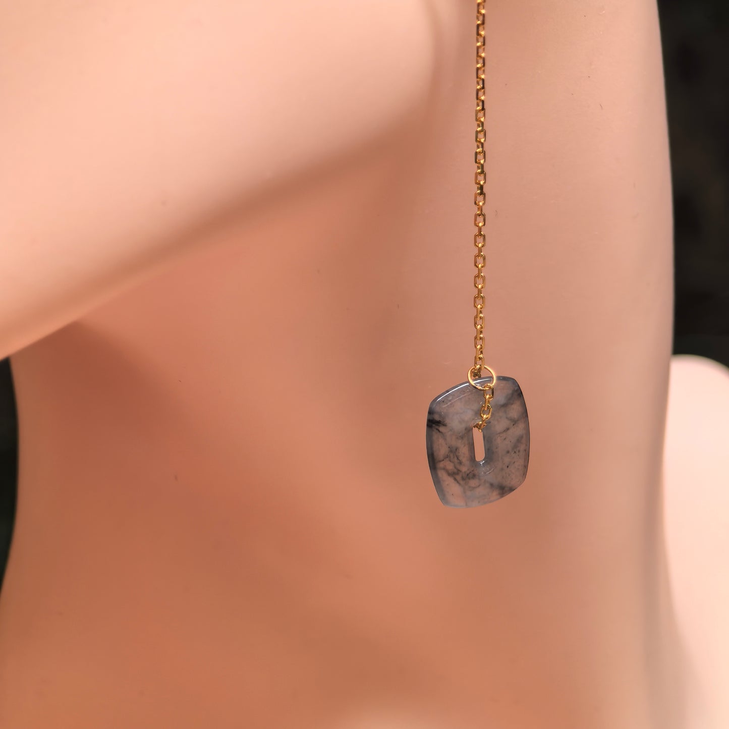 Natural Grade-A icy black-gray jadeite 18K gold thread earring shown on display model.
