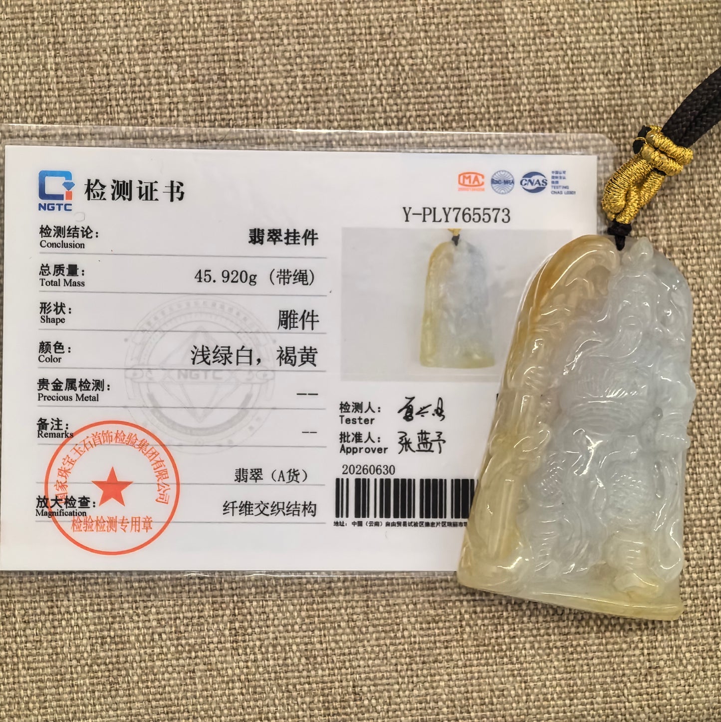 NGTC certified white and yellow jadeite Guan Gong pendant shown with matching certificate.
