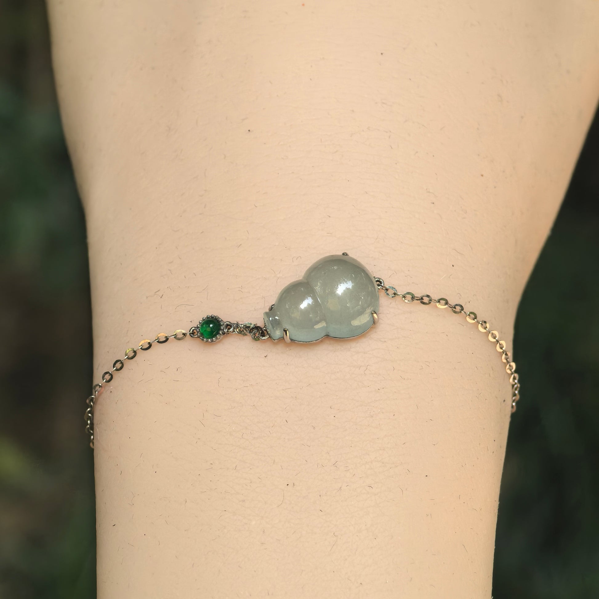 Close-up of light green icy jadeite gourd bracelet showing smooth luster and 18K gold setting.
