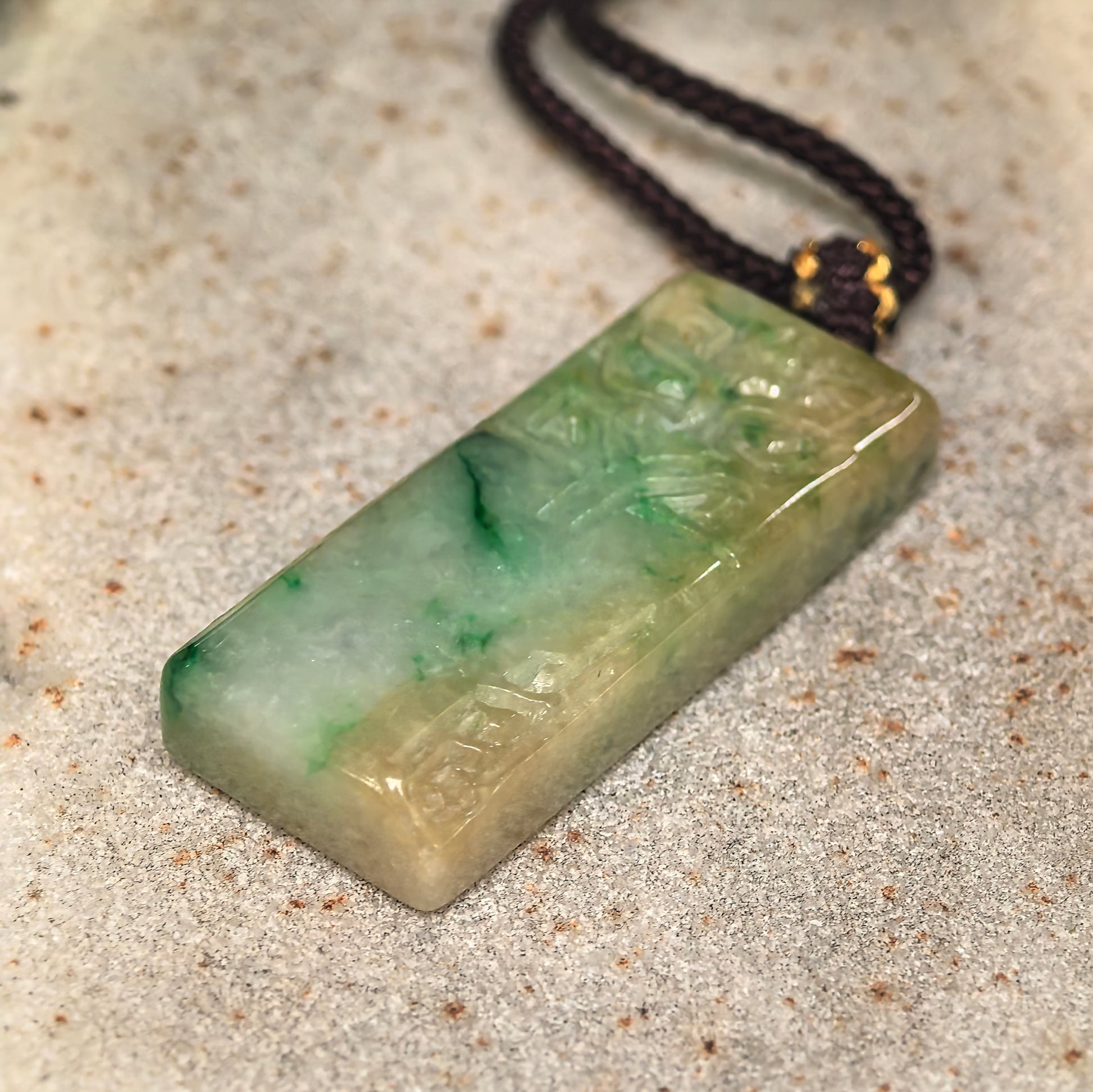 Side view of natural Grade-A jadeite plain plaque pendant showing thickness and polished surface.
